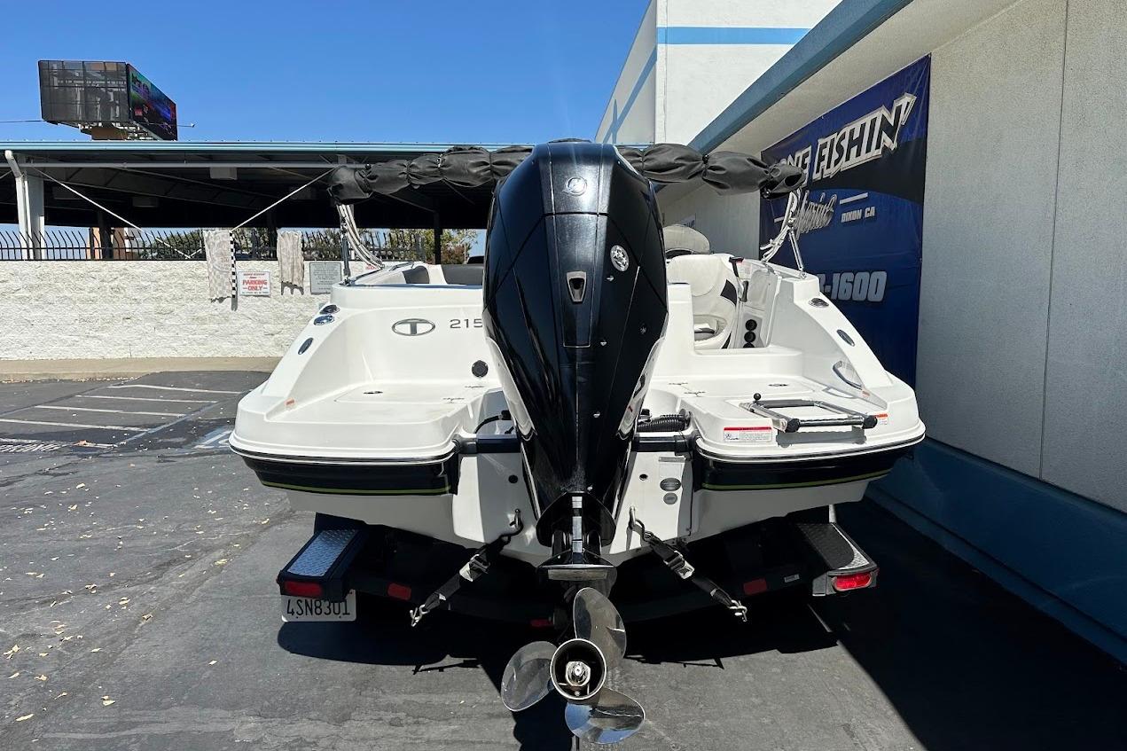 2019 Tahoe 2150 boat with outboard motor in parking lot.
