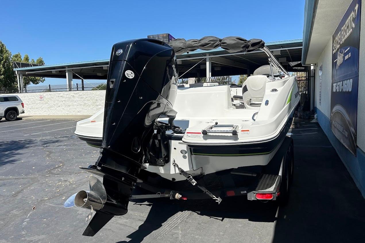 2019 Tahoe 2150 boat with outboard motor in a parking lot.