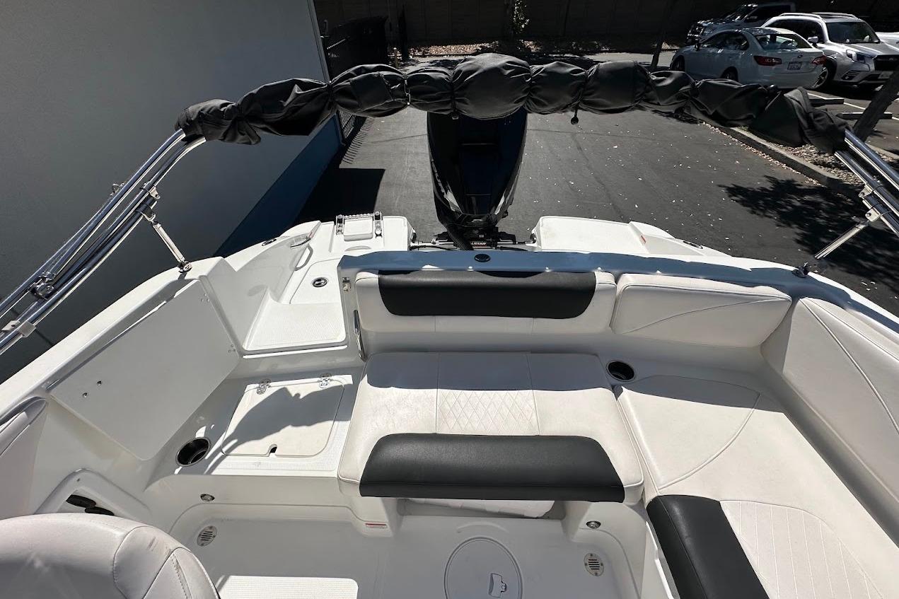 2019 Tahoe 2150 boat interior with white seating and black accents, parked outdoors.