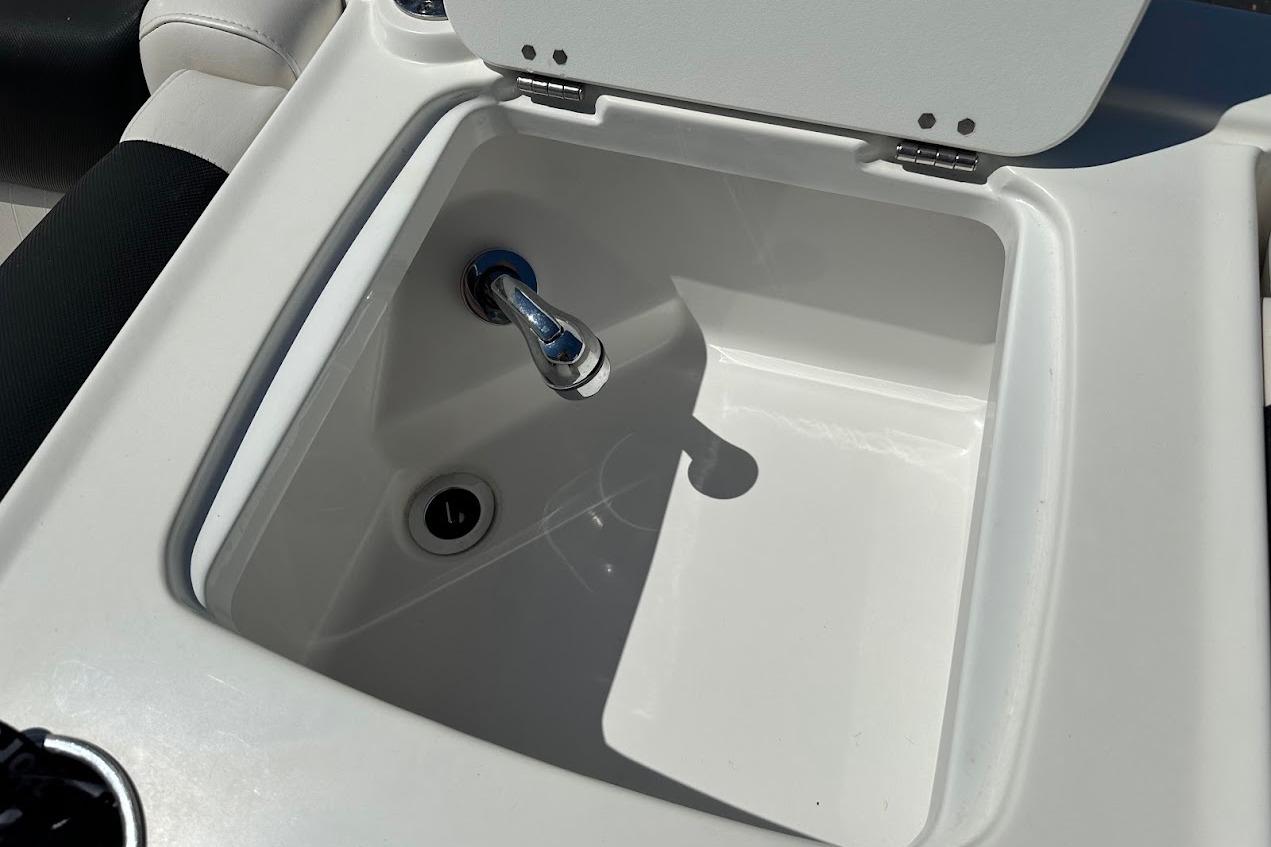 2019 Tahoe 2150 boat sink with faucet and open lid.