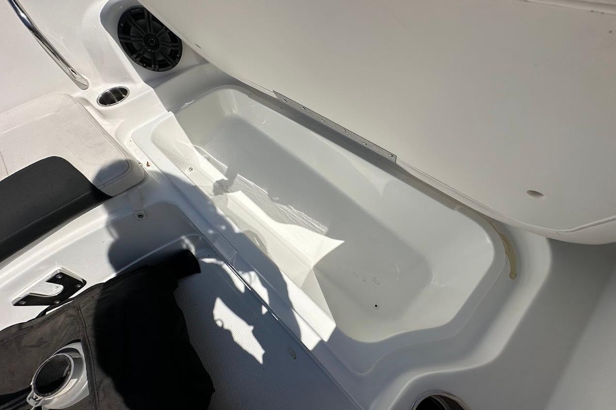 Interior of a 2019 Tahoe 2150 boat showing storage compartment and seating area.