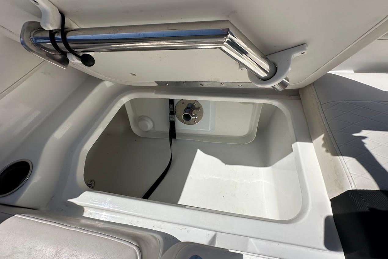 2019 Tahoe 2150 boat storage compartment with stainless steel handle and white interior.