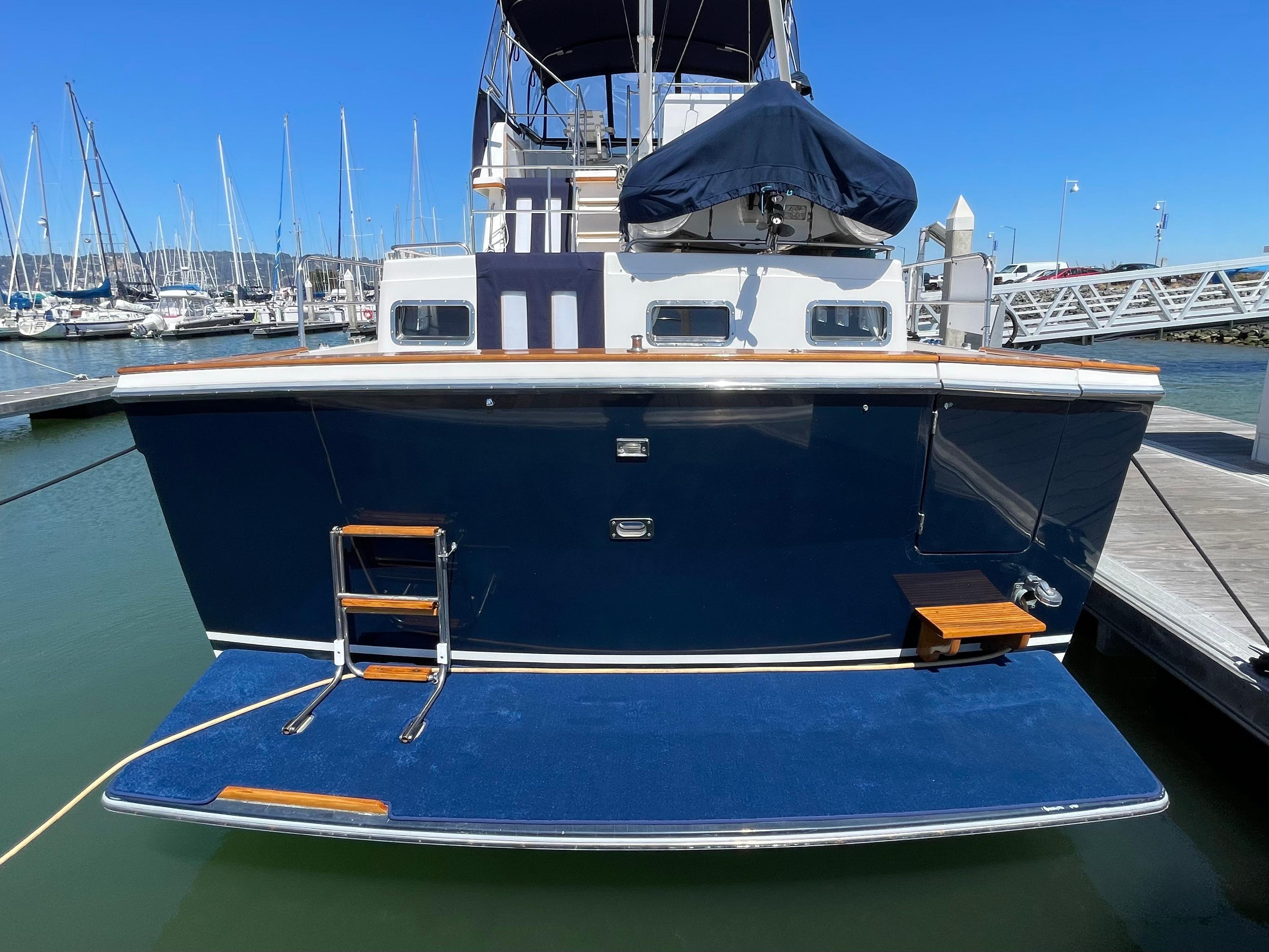 1997 Sabre Cockpit Motor Yacht docked, featuring a blue hull and swim platform.
