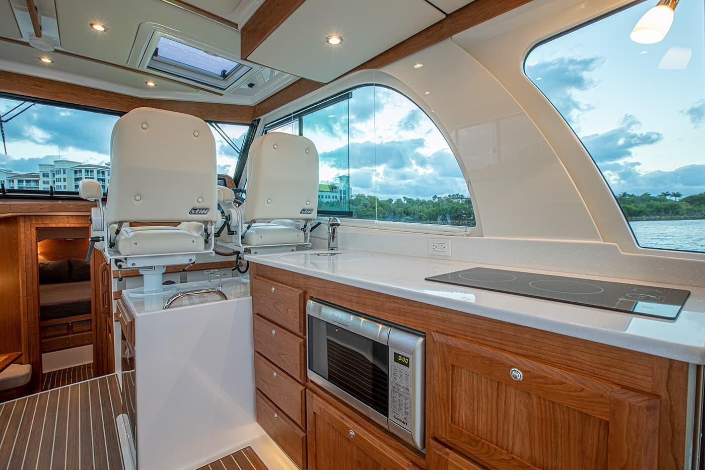 Luxurious interior of 2027 Back Cove 39O yacht with modern kitchen and seating.