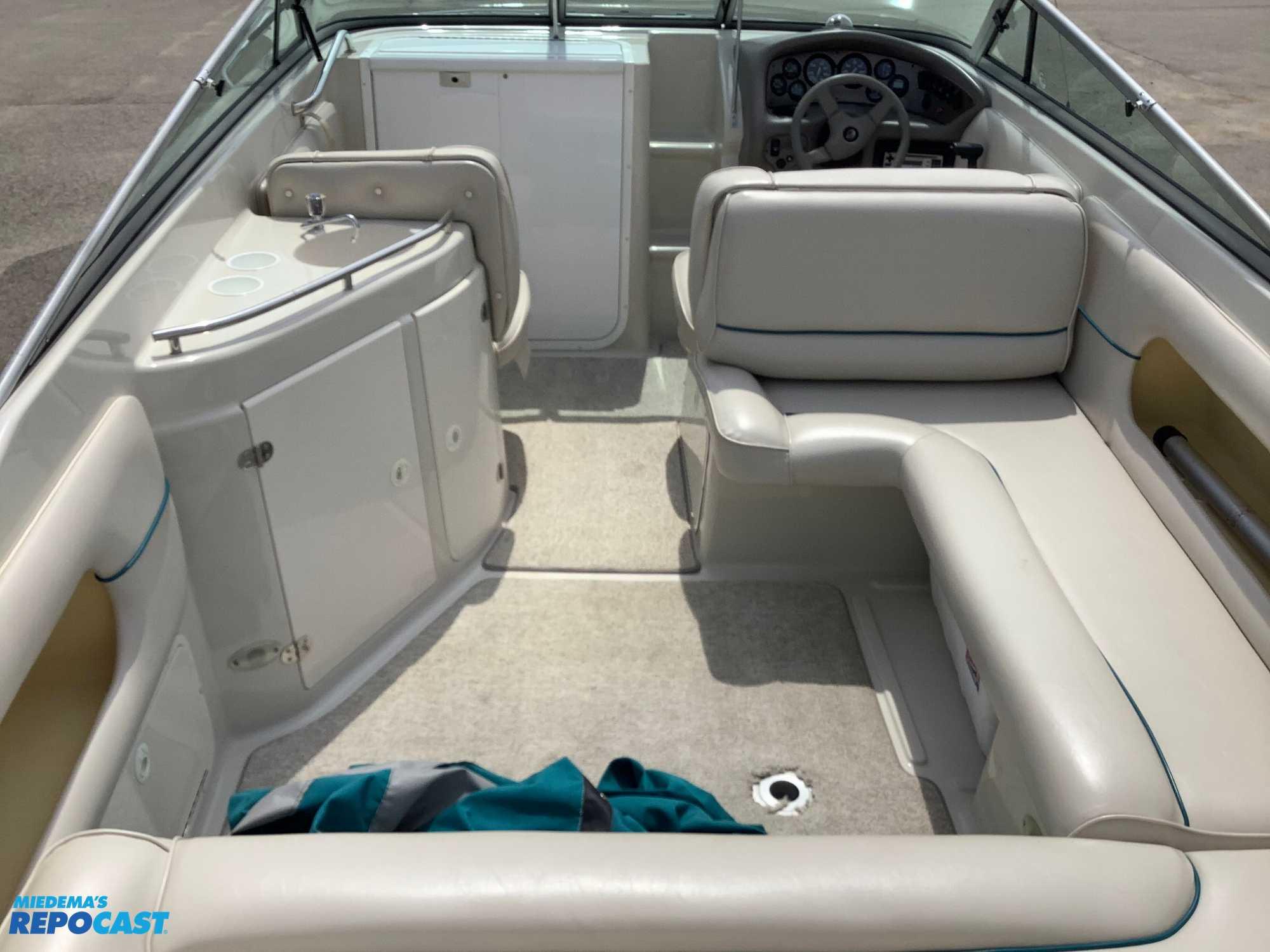 1999 Crownline 266 CCR boat interior with seating, steering wheel, and storage compartments.
