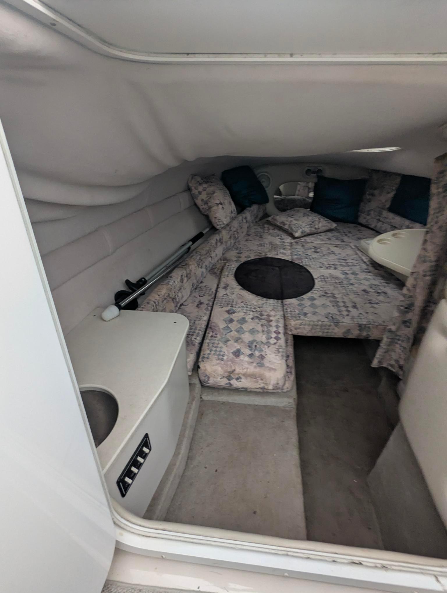 1999 Crownline 266 CCR cabin interior with seating and cushions.
