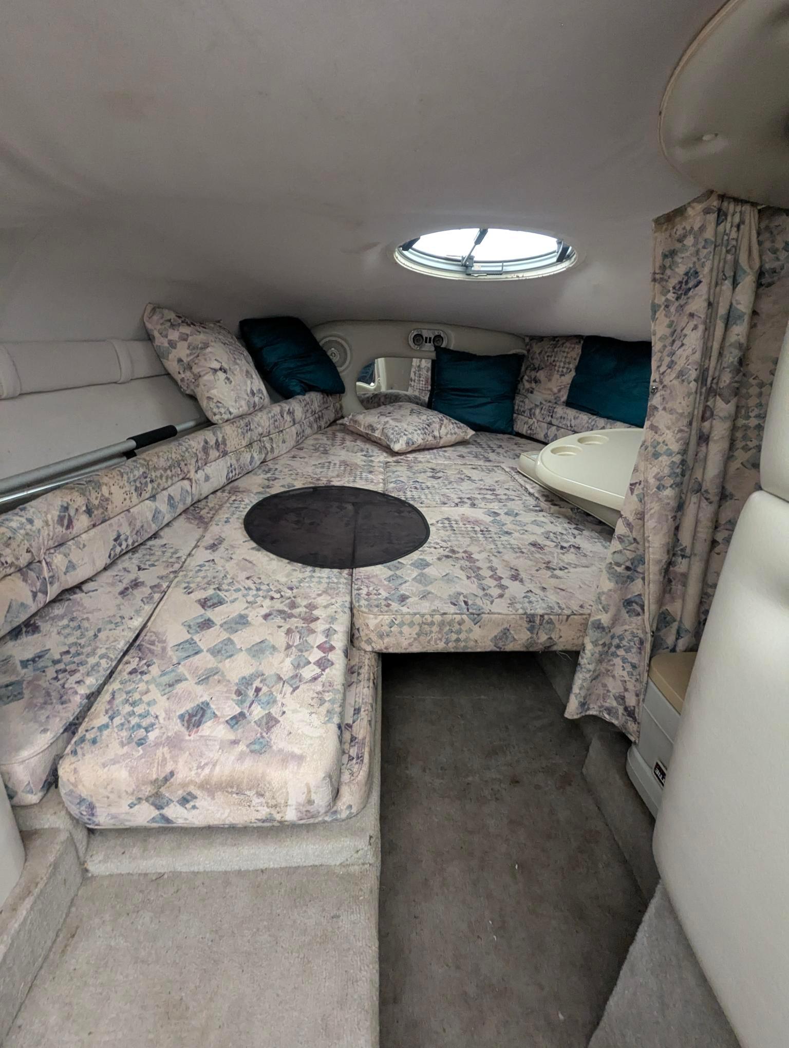 1999 Crownline 266 CCR cabin interior with floral upholstery and round window.