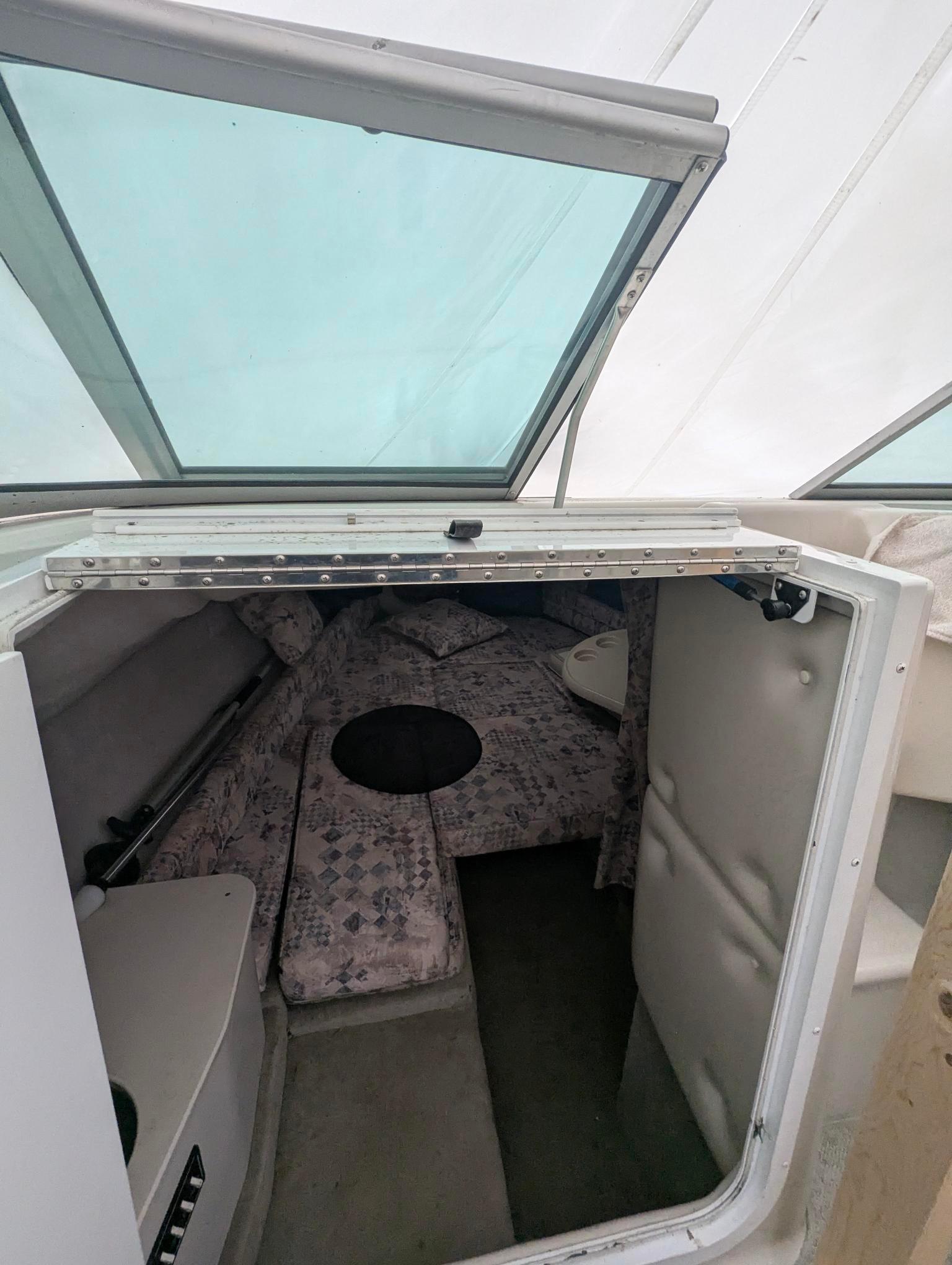 1999 Crownline 266 CCR cabin interior with seating and windows.