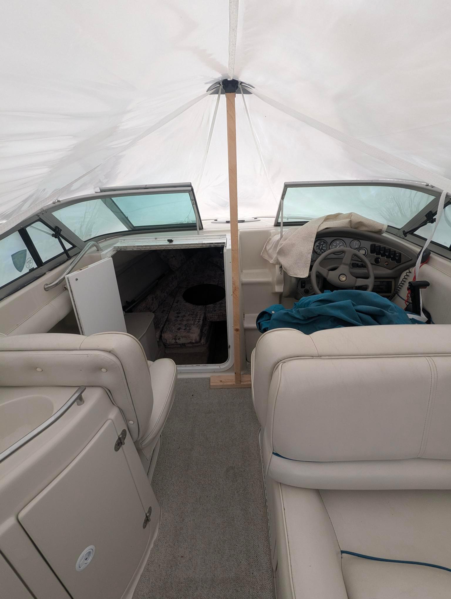1999 Crownline 266 CCR boat interior with covered seating and steering area.