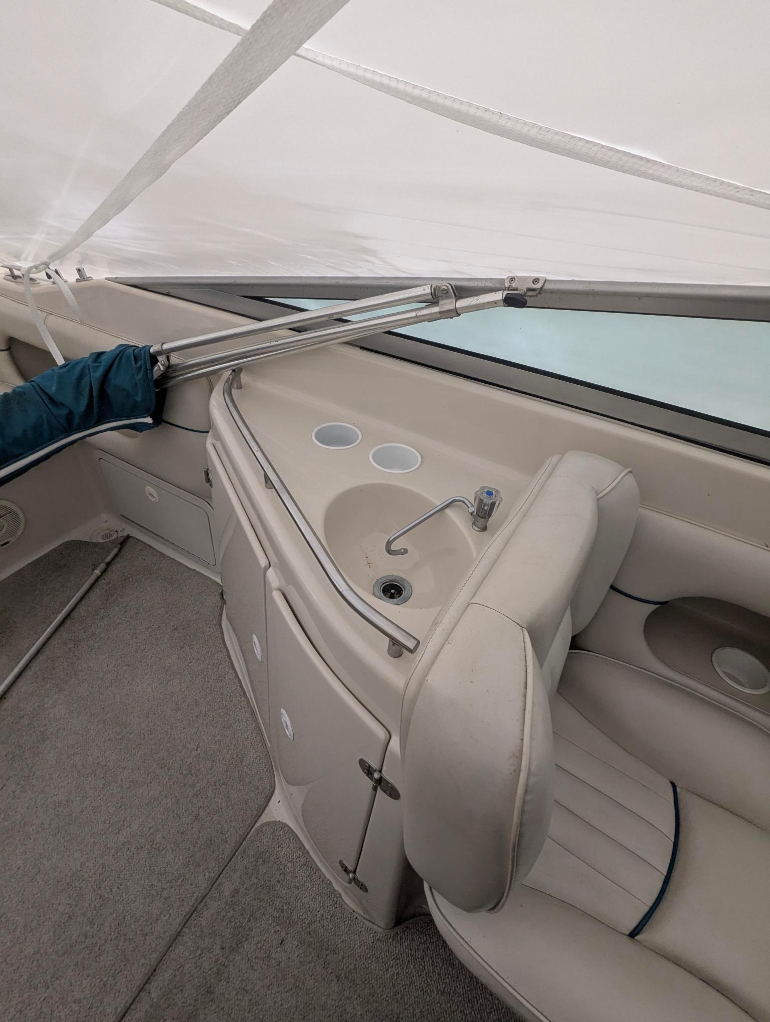 1999 Crownline 266 CCR boat interior with sink and seating area.