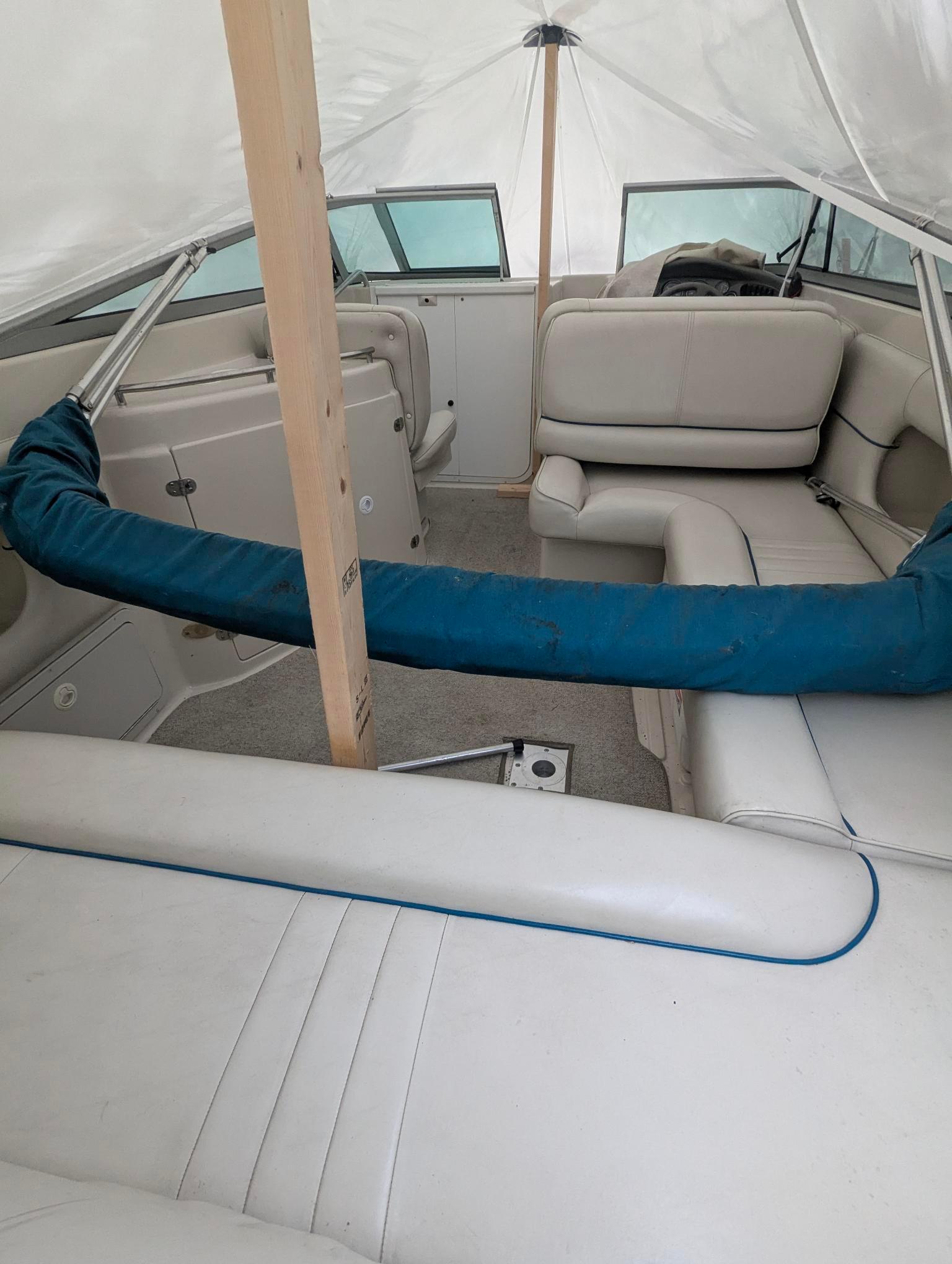 1999 Crownline 266 CCR boat interior with white seating and protective cover.