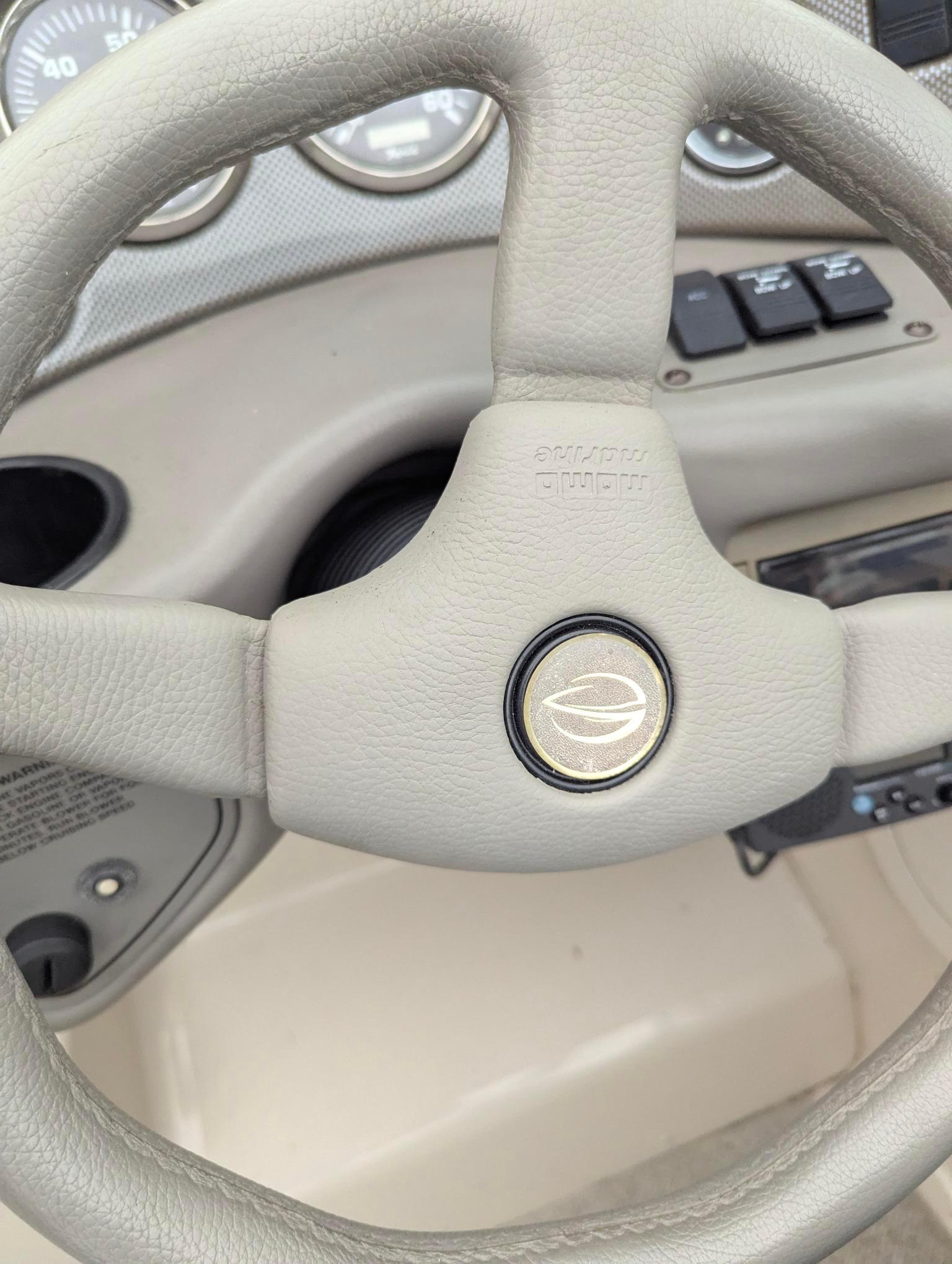 Steering wheel of a 1999 Crownline 266 CCR boat, featuring control panel and gauges.