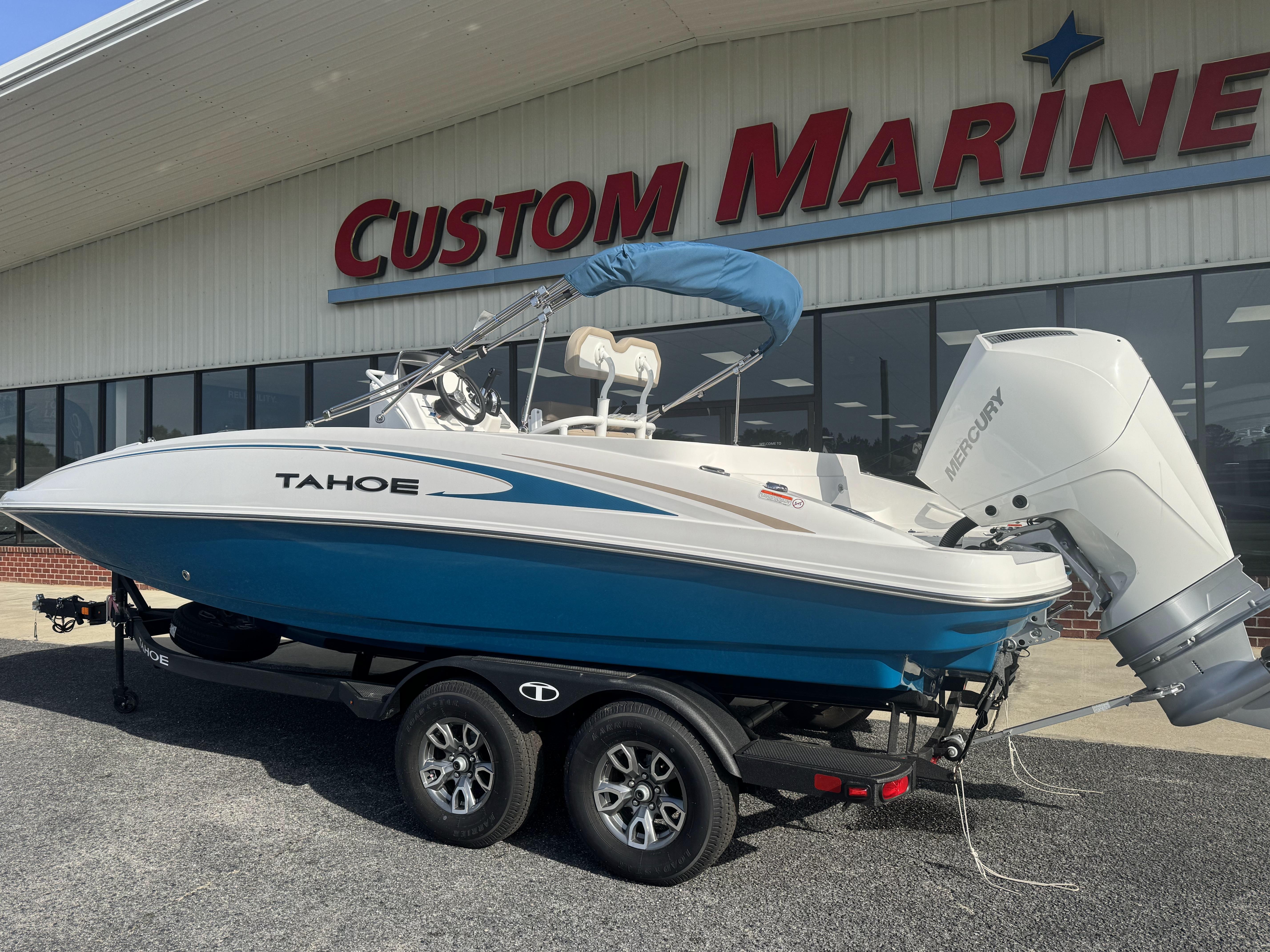 2025 Tahoe 2150 CC boat on trailer at Custom Marine dealership.