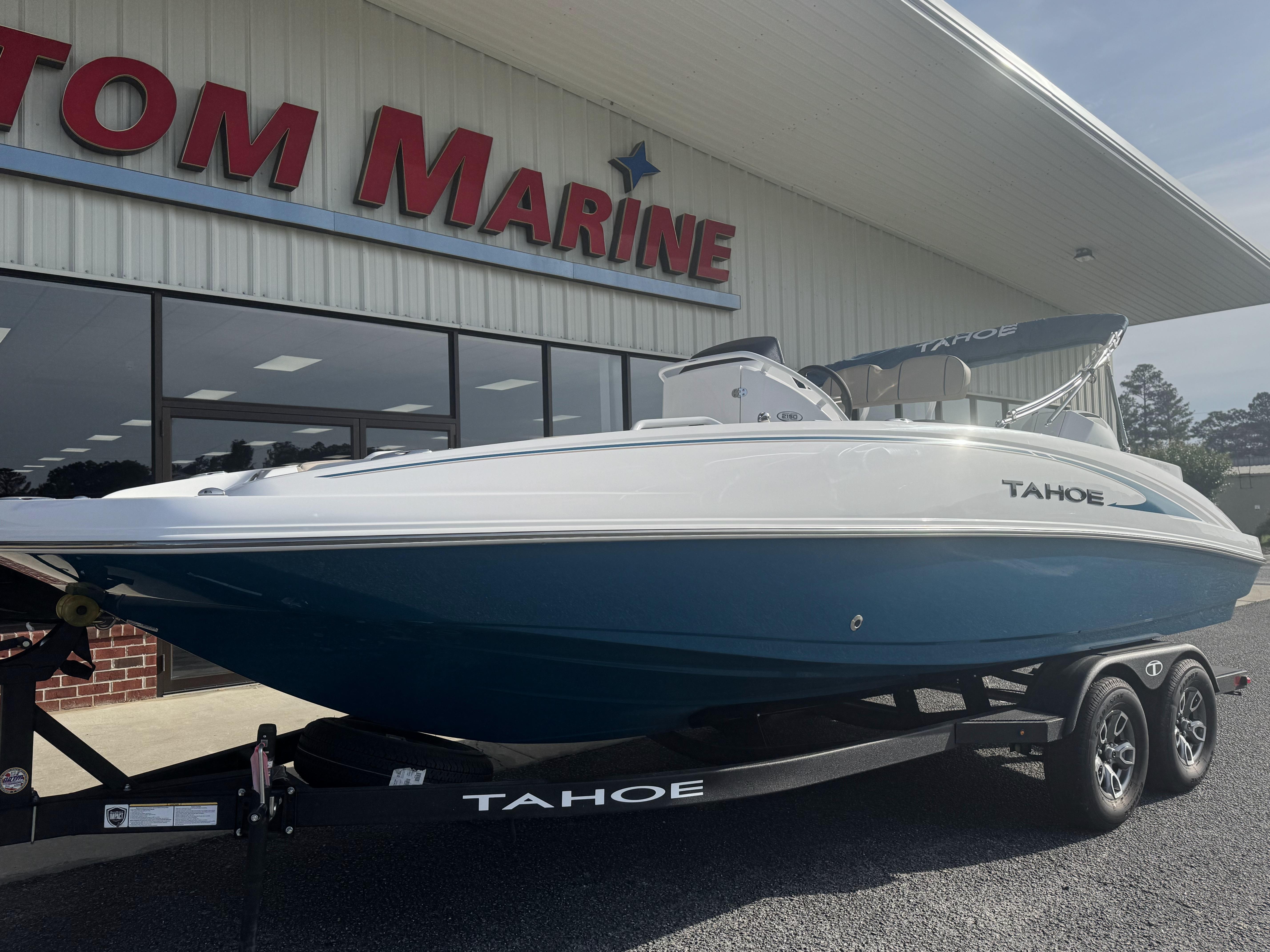 2025 Tahoe 2150 CC boat on trailer outside marine dealership.