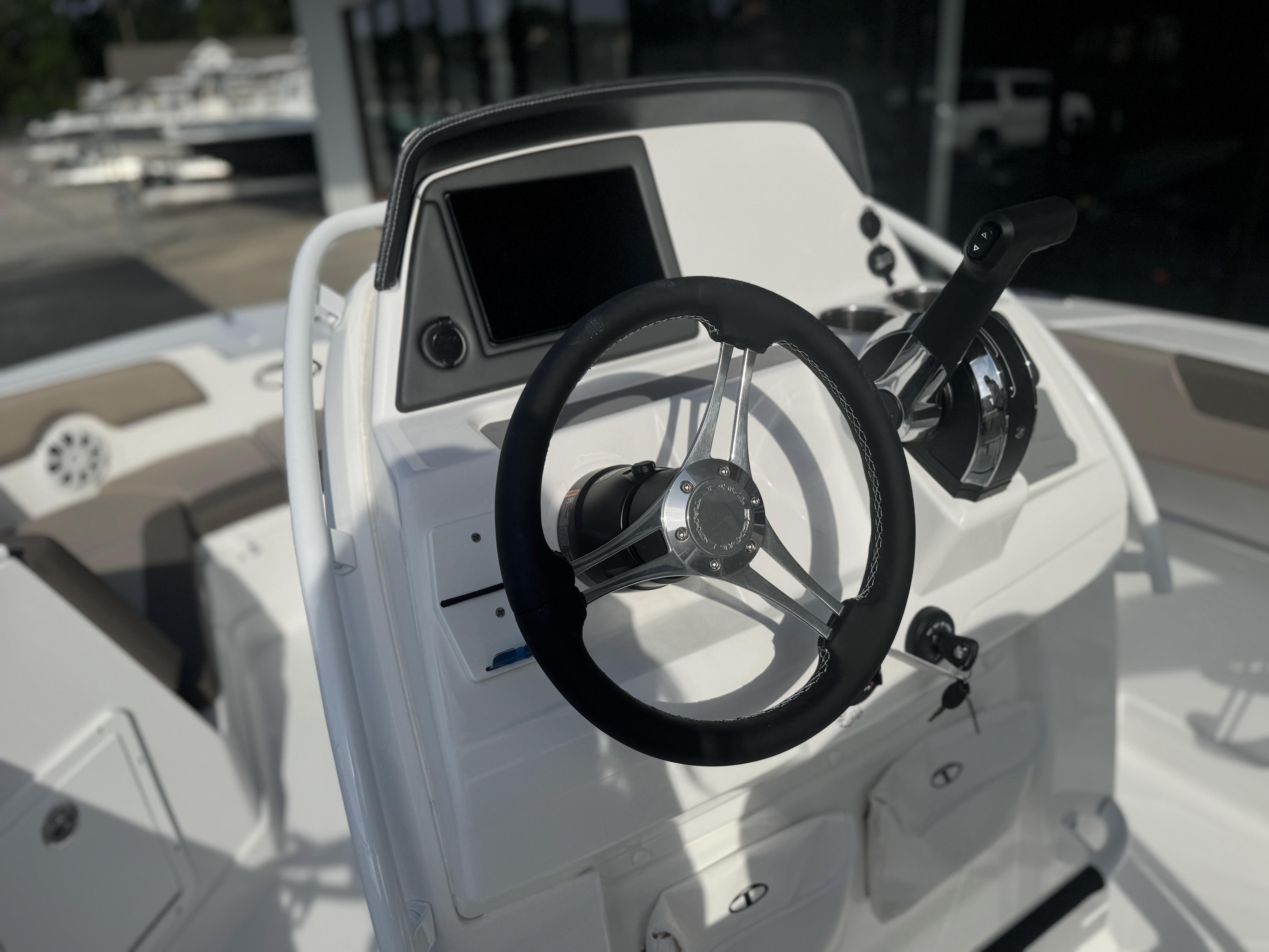 2025 Tahoe 2150 CC boat helm with steering wheel and controls.