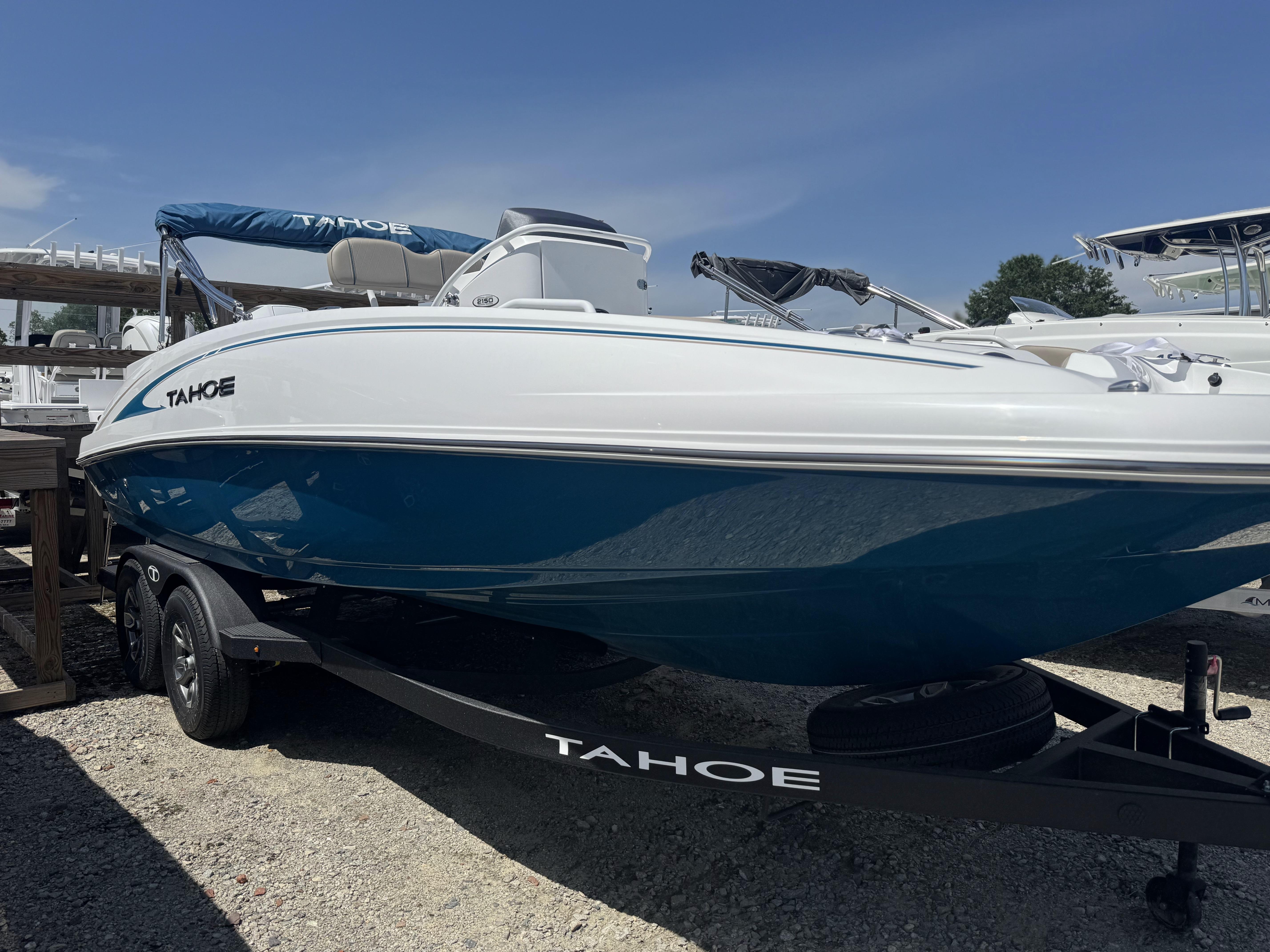 2025 Tahoe 2150 CC boat with blue hull on trailer, parked outdoors.