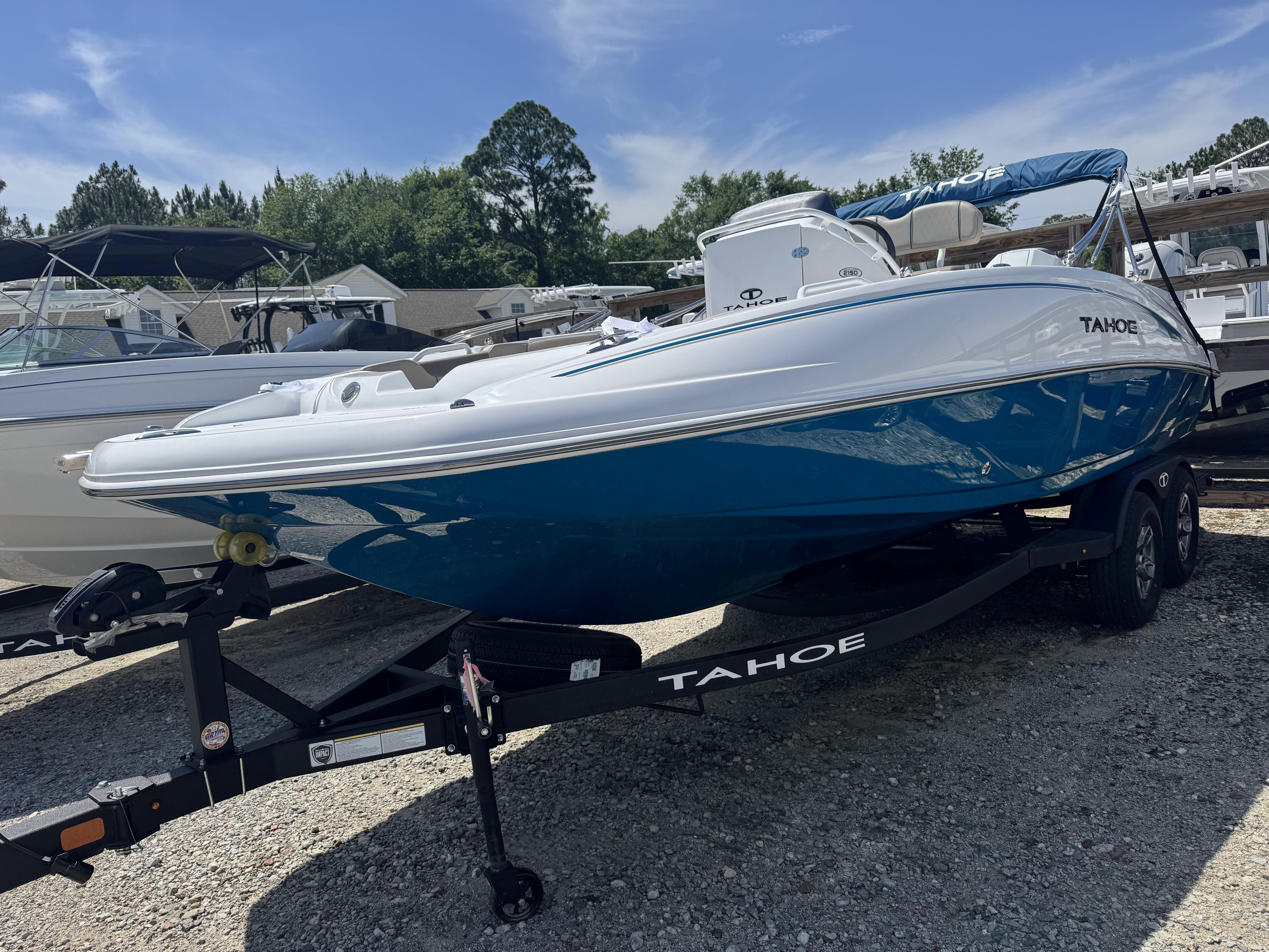 2025 Tahoe 2150 CC boat on trailer, blue and white design, parked outdoors.