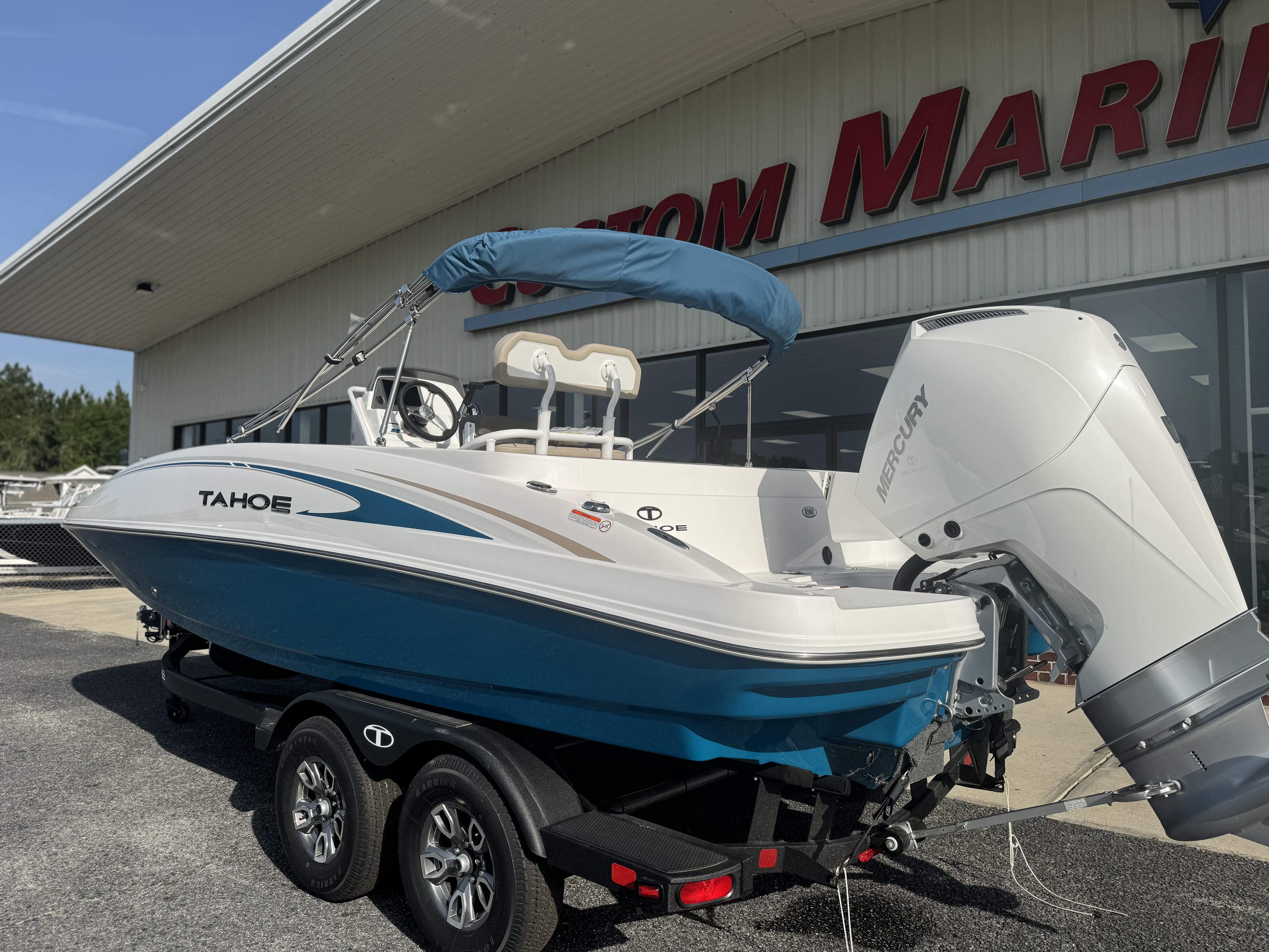 2025 Tahoe 2150 CC boat with Mercury engine on trailer outside marine store.