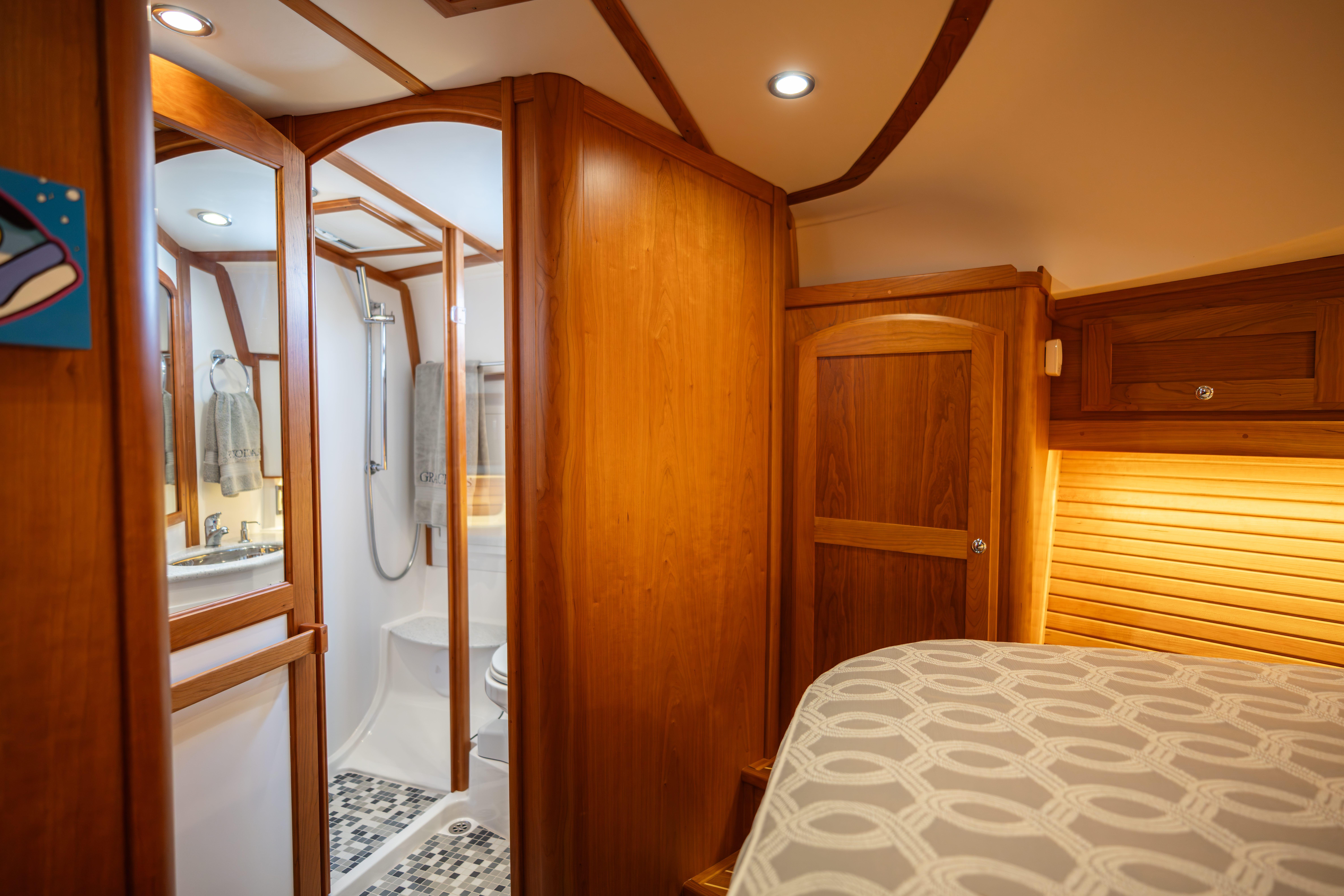2020 Sabre 48 Salon Express interior with wooden cabinetry and modern bathroom.