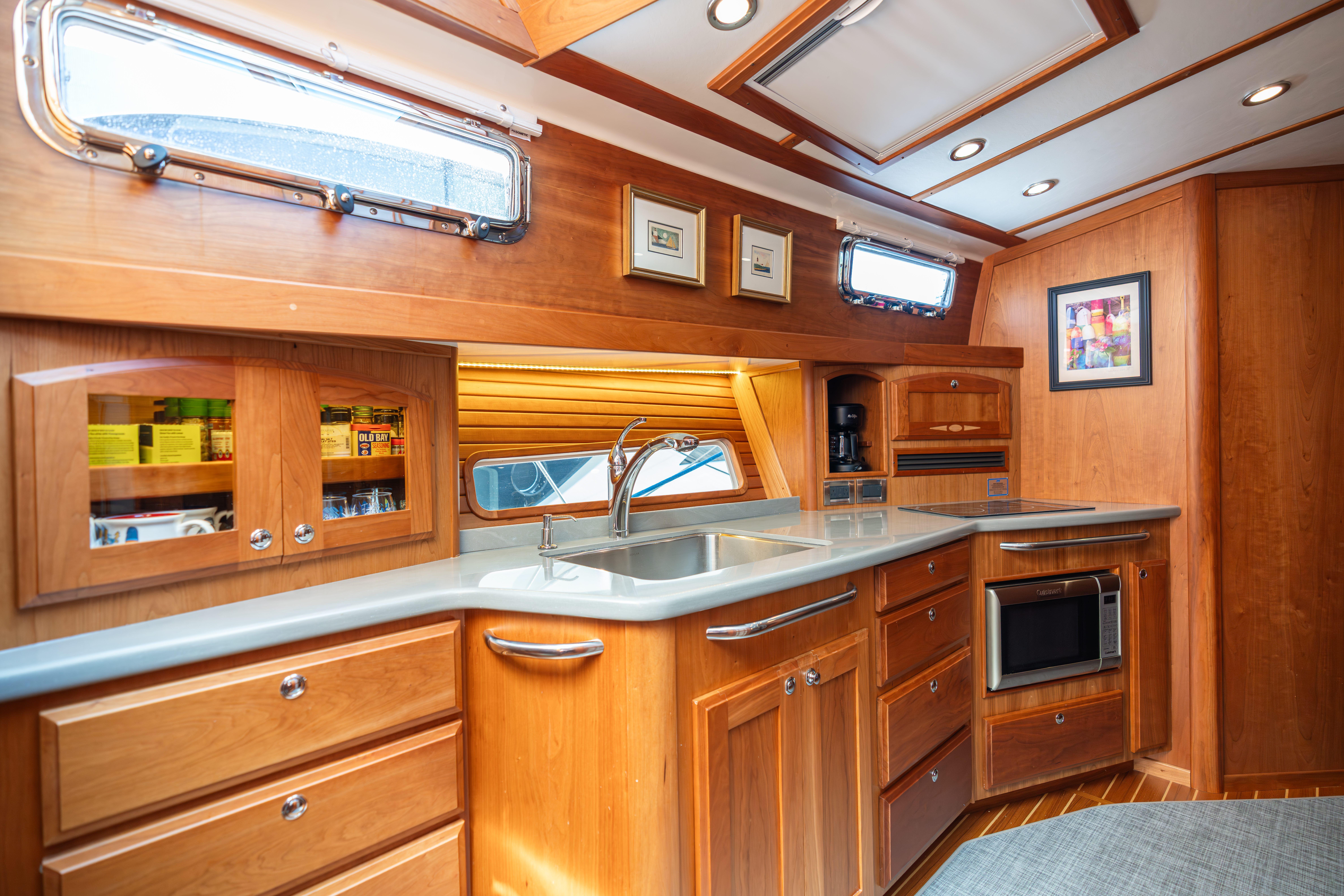 2020 Sabre 48 Salon Express kitchen with wooden cabinetry and modern appliances.