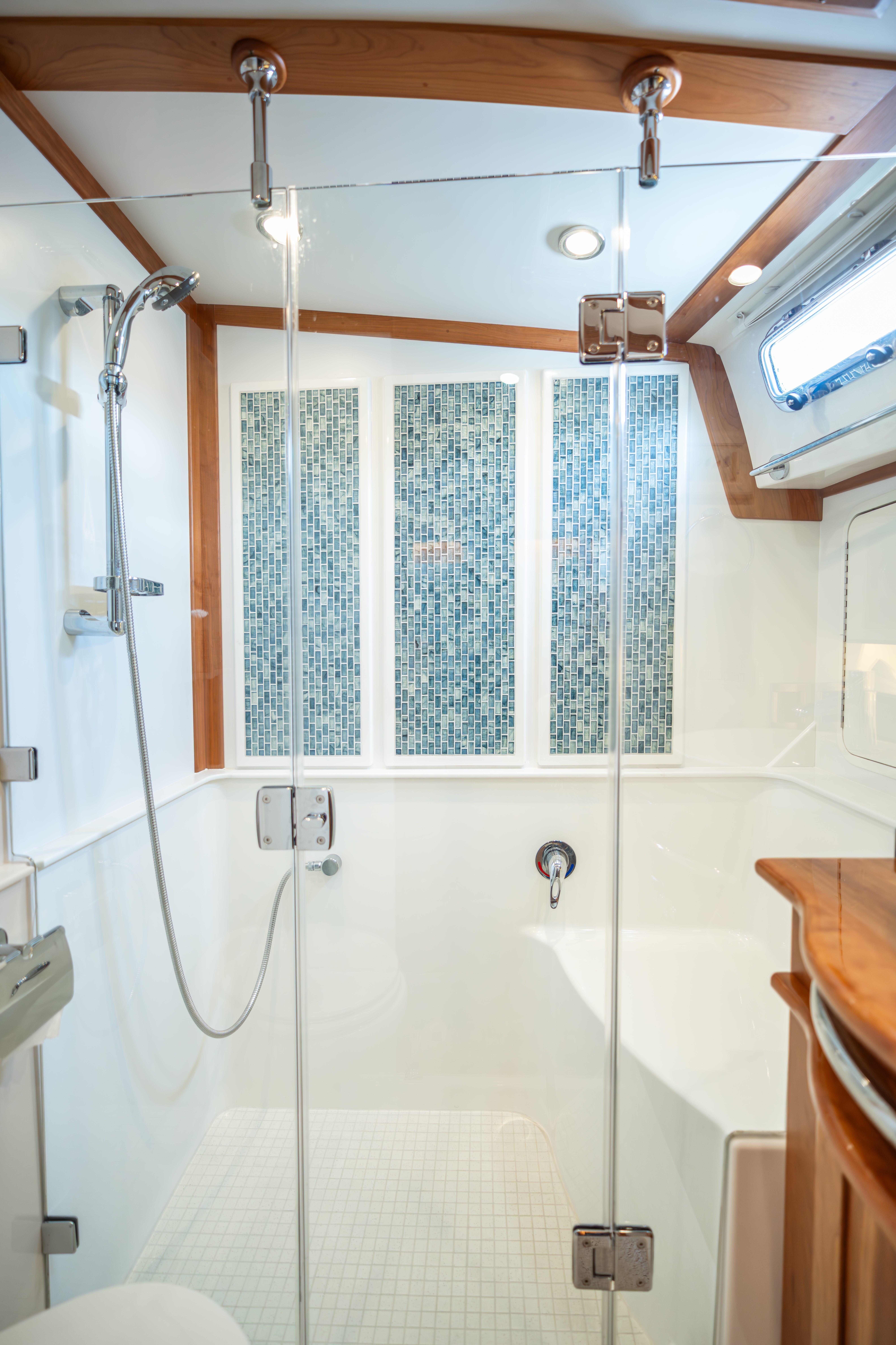 Luxurious bathroom in 2020 Sabre 48 Salon Express yacht with glass shower and mosaic tiles.