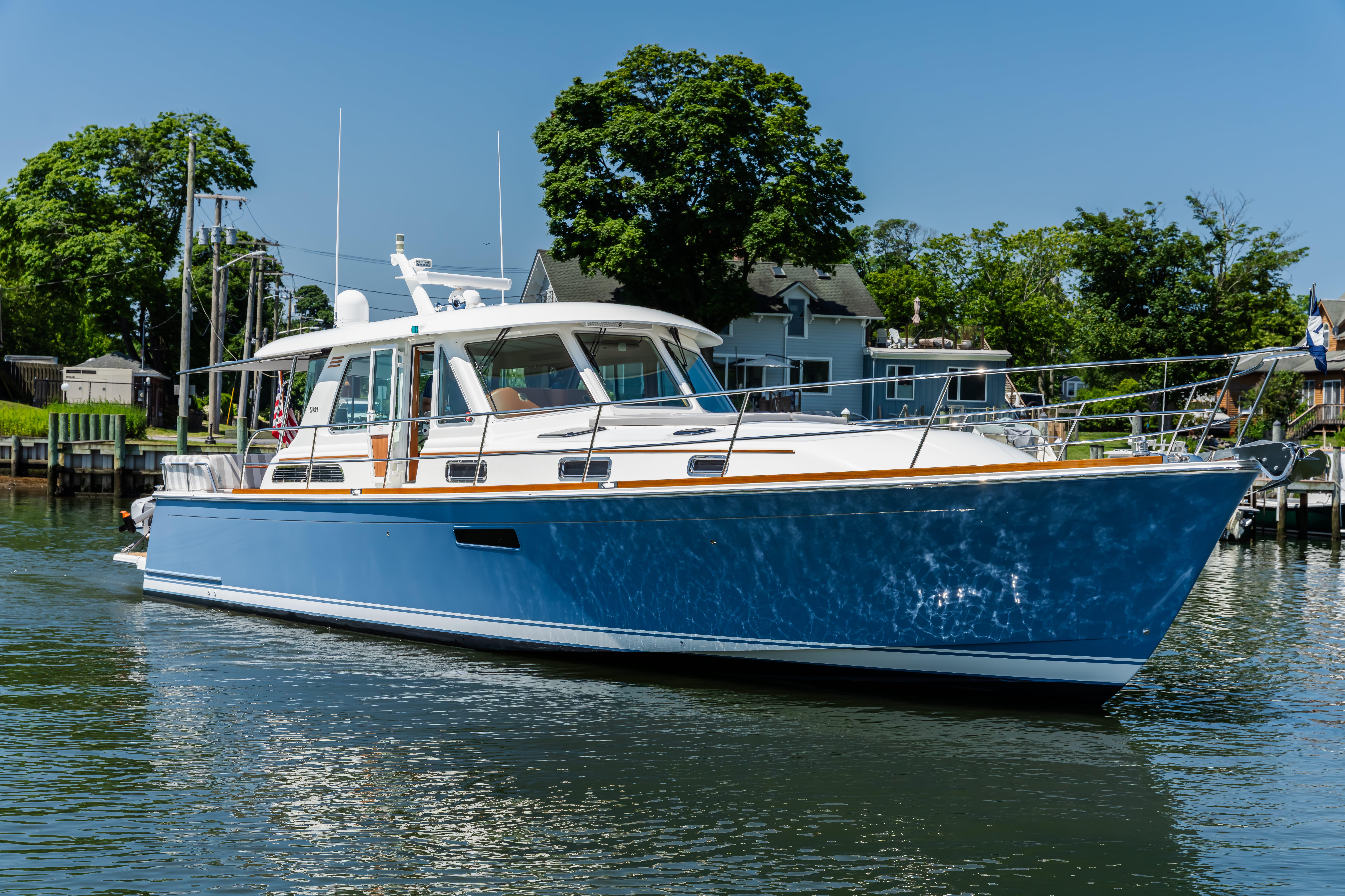 2020 Sabre 48 Salon Express yacht on calm water, surrounded by greenery.