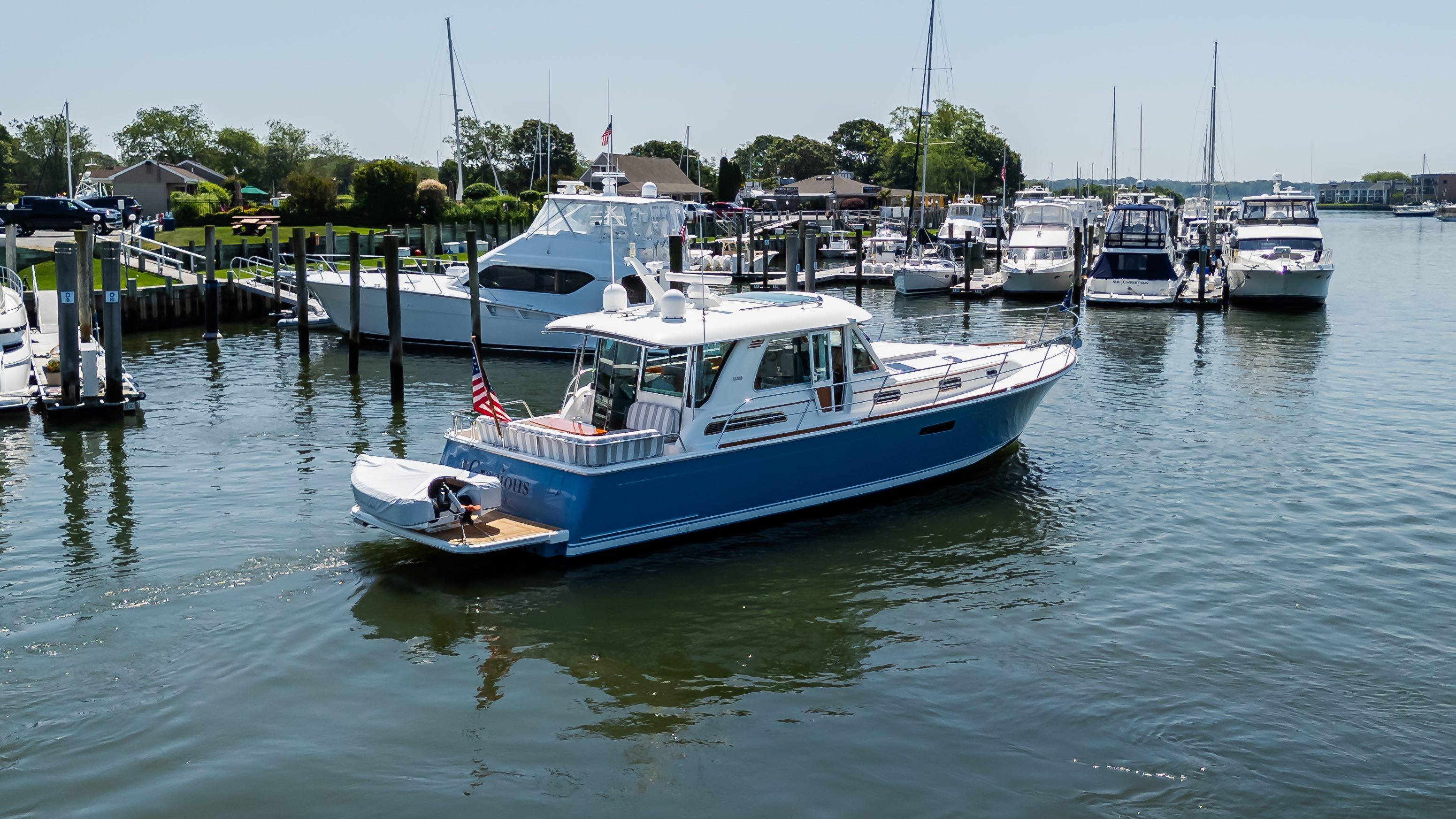 2020 Sabre 48 Salon Express yacht docked in a marina, surrounded by other boats.