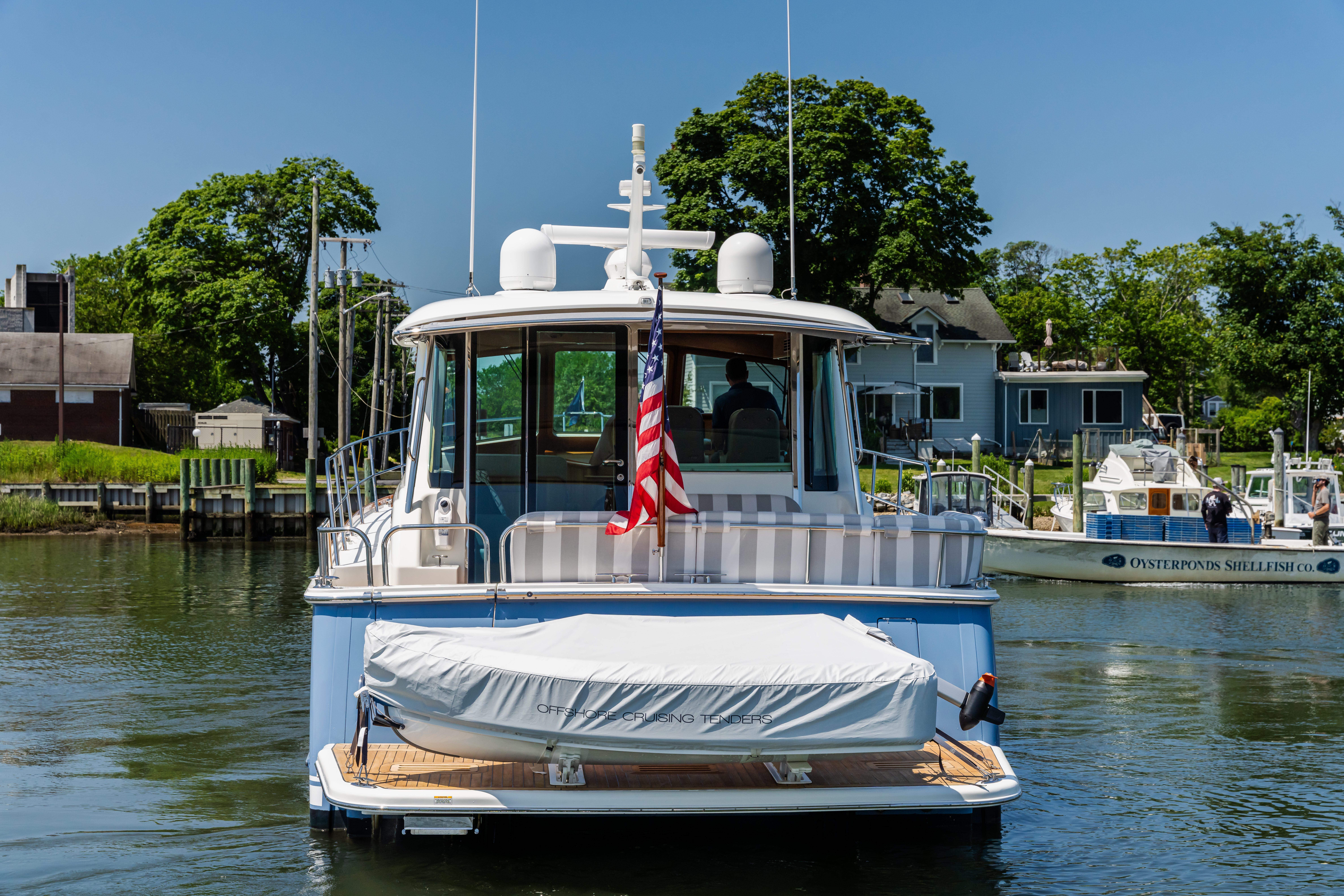 2020 Sabre 48 Salon Express yacht docked with American flag, sunny day.