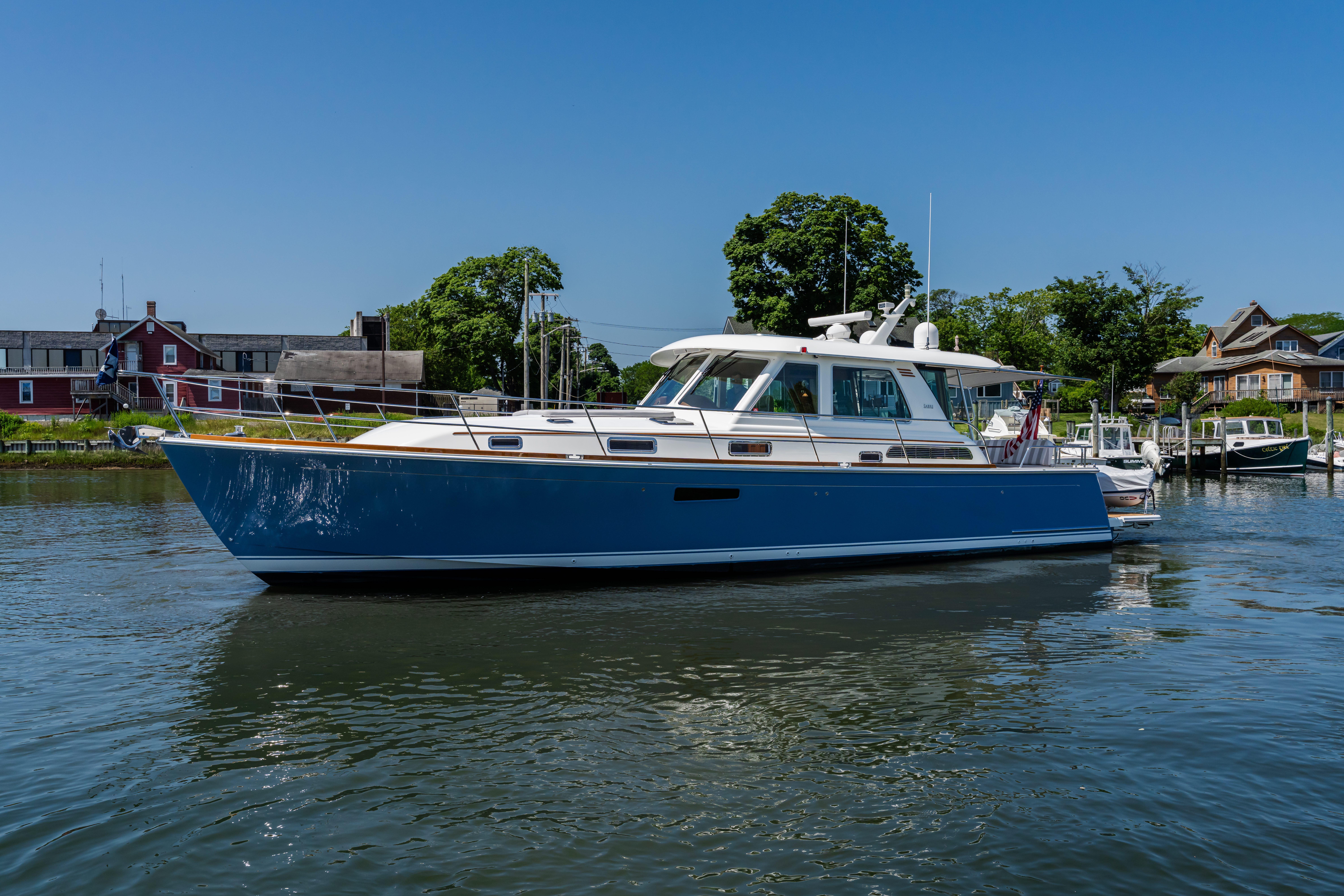2020 Sabre 48 Salon Express yacht on calm water, with scenic background.