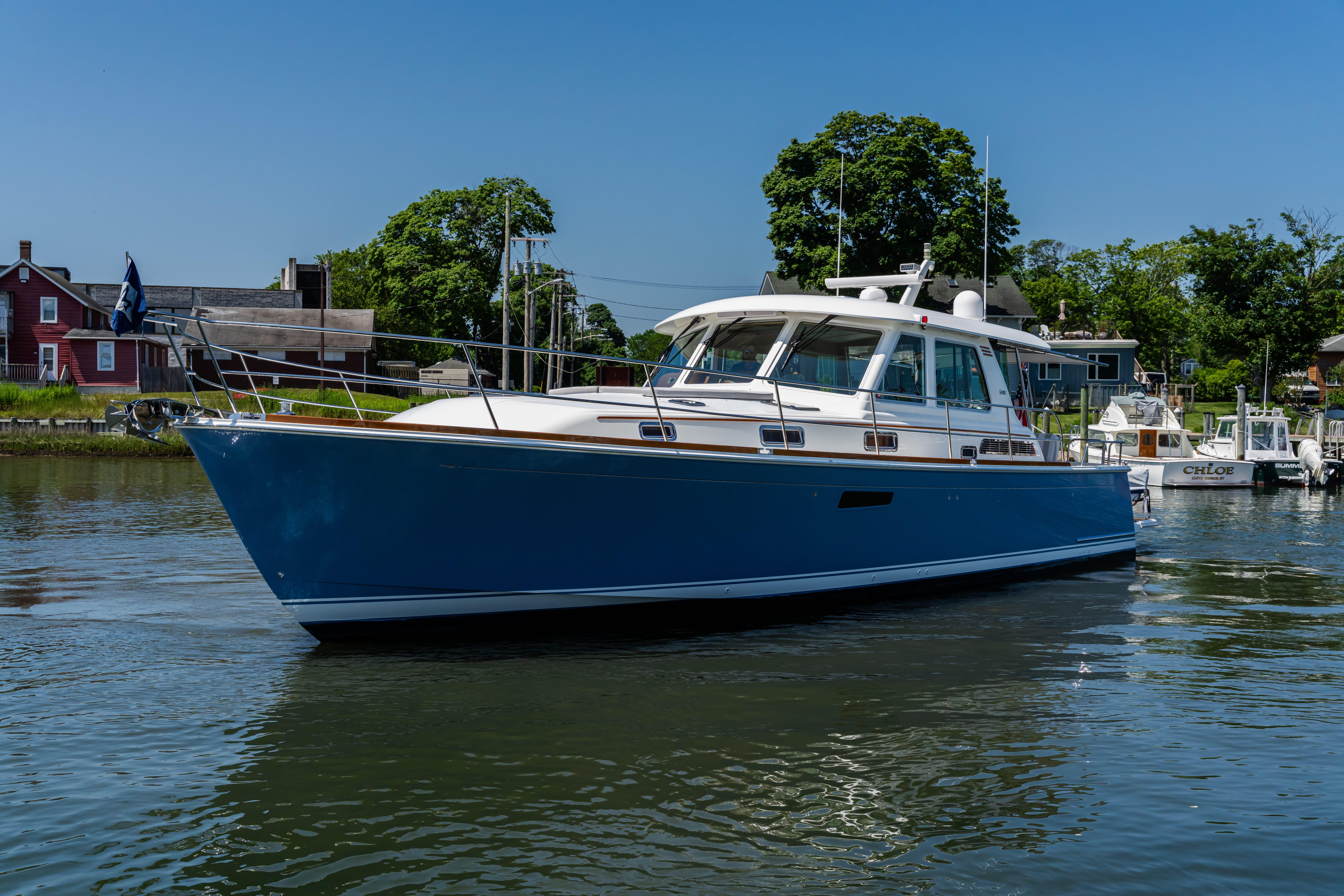2020 Sabre 48 Salon Express yacht on calm water, with scenic background.
