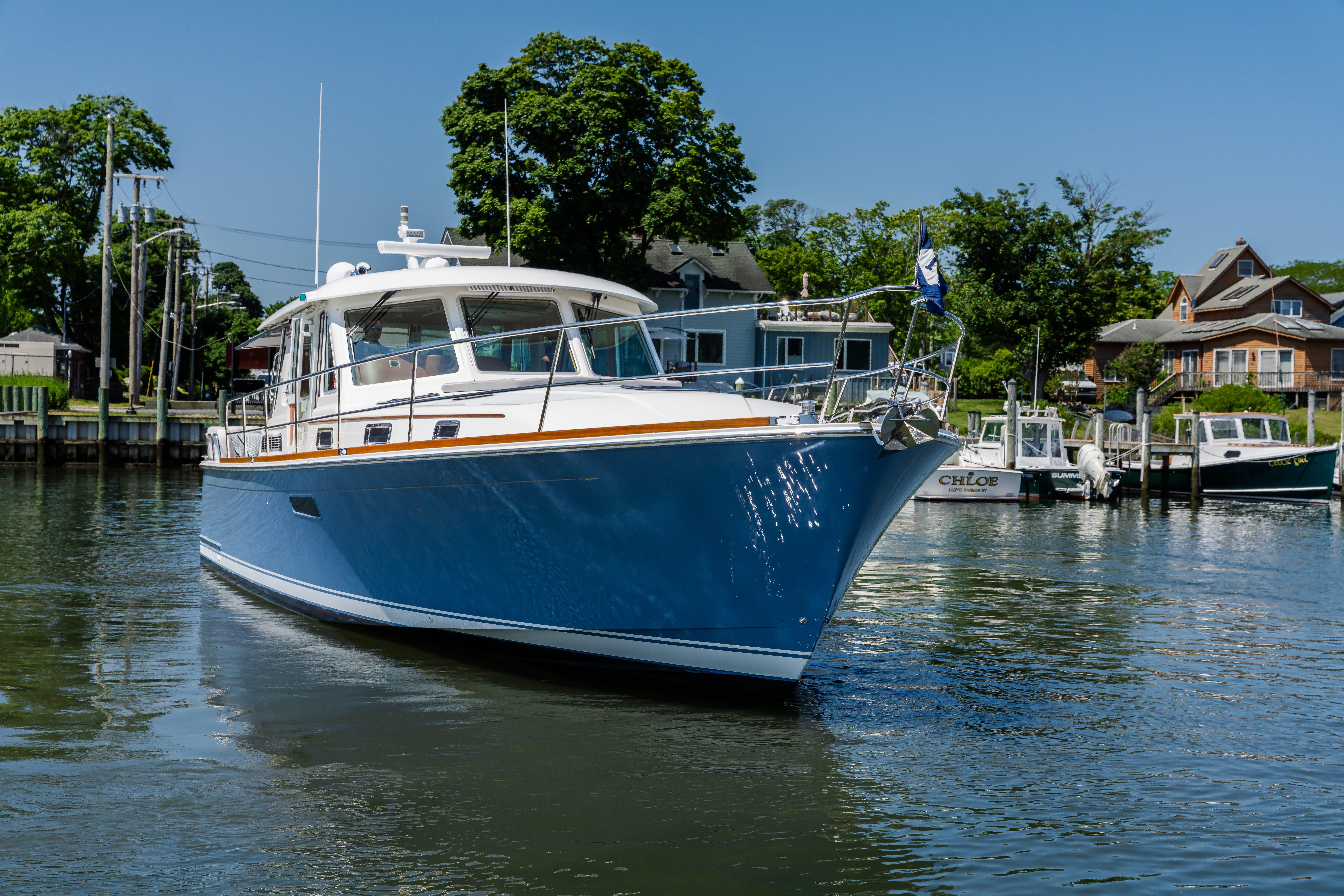 2020 Sabre 48 Salon Express yacht on calm water near a marina.