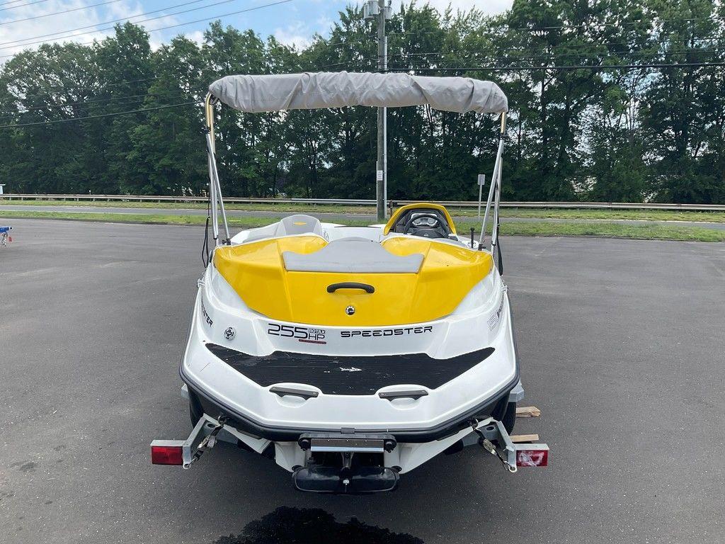 2009 Sea-Doo 150 Speedster 255 boat with yellow accents, parked on pavement.