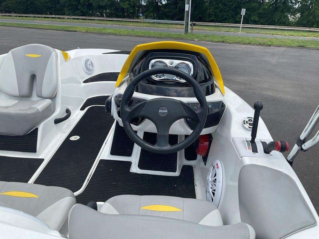 2009 Sea-Doo 150 Speedster 255 interior with steering wheel and seats, parked on asphalt.