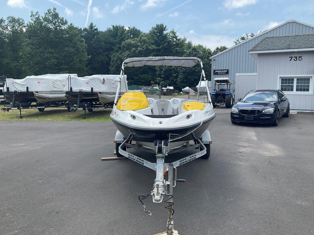 2009 Sea-Doo 150 Speedster 255 on trailer, parked near a building and other boats.