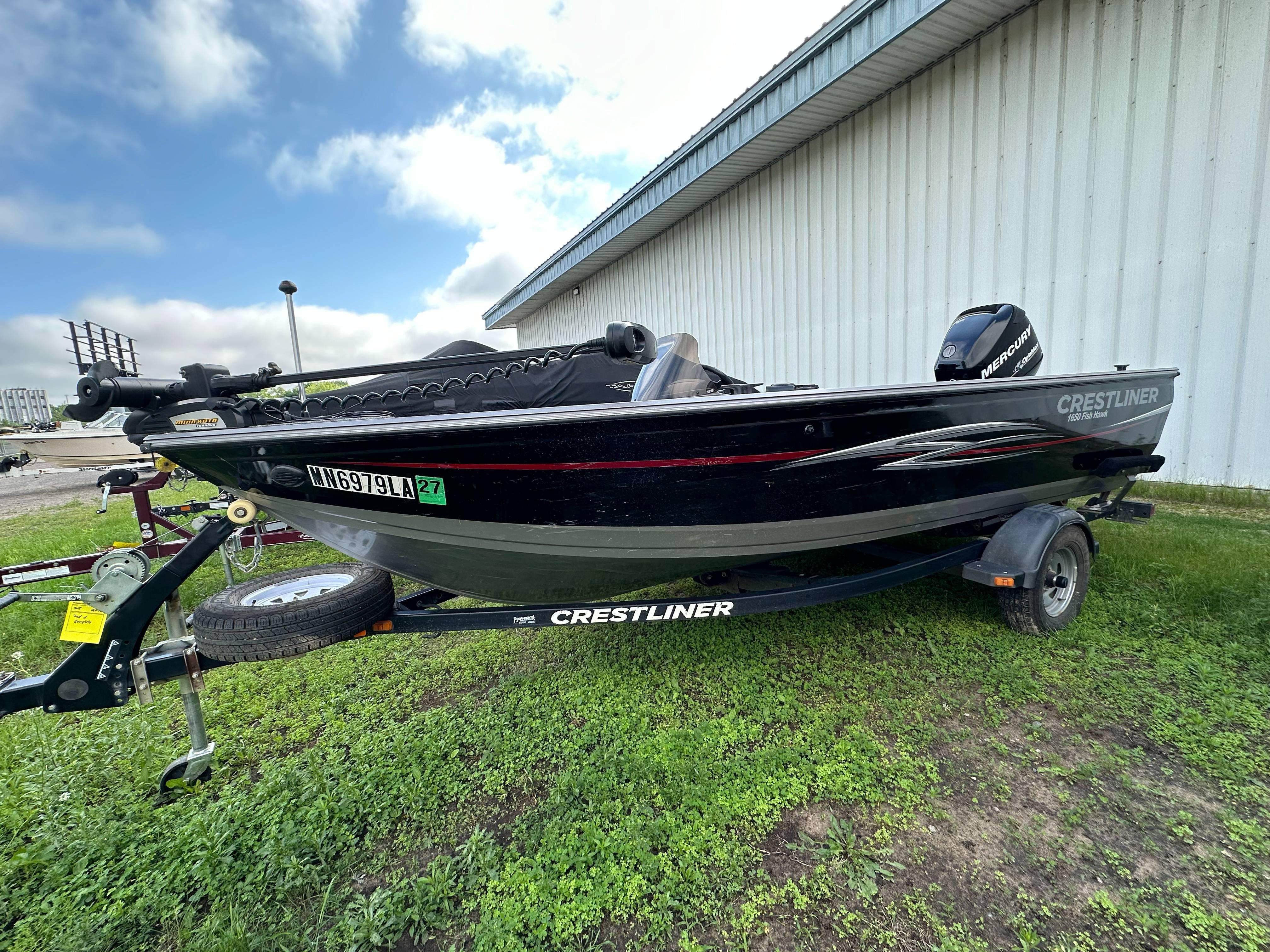 2013 Crestliner Fish Hawk 1650 SC boat on trailer, parked on grass.