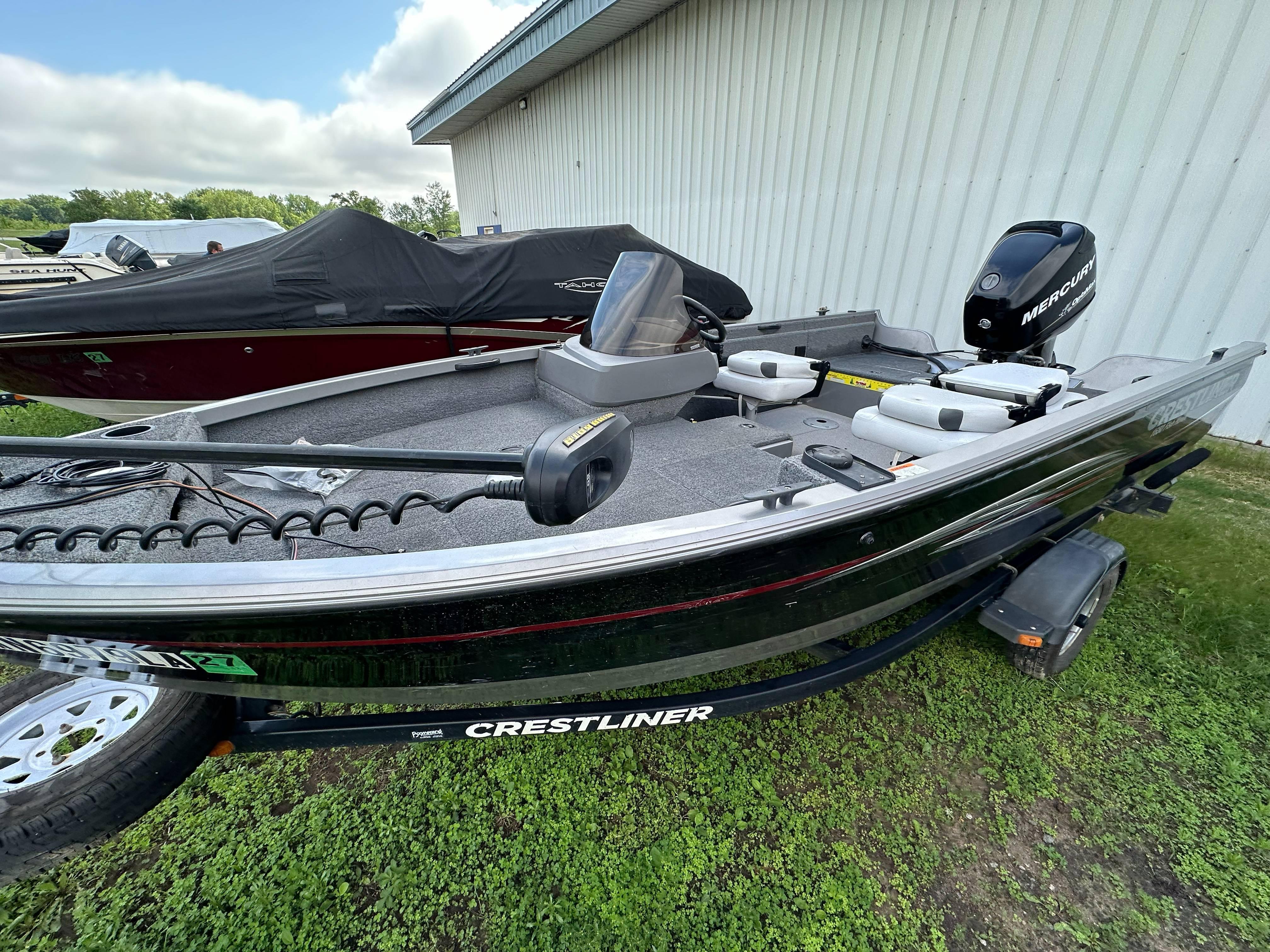 2013 Crestliner Fish Hawk 1650 SC boat with Mercury engine, parked on grass.