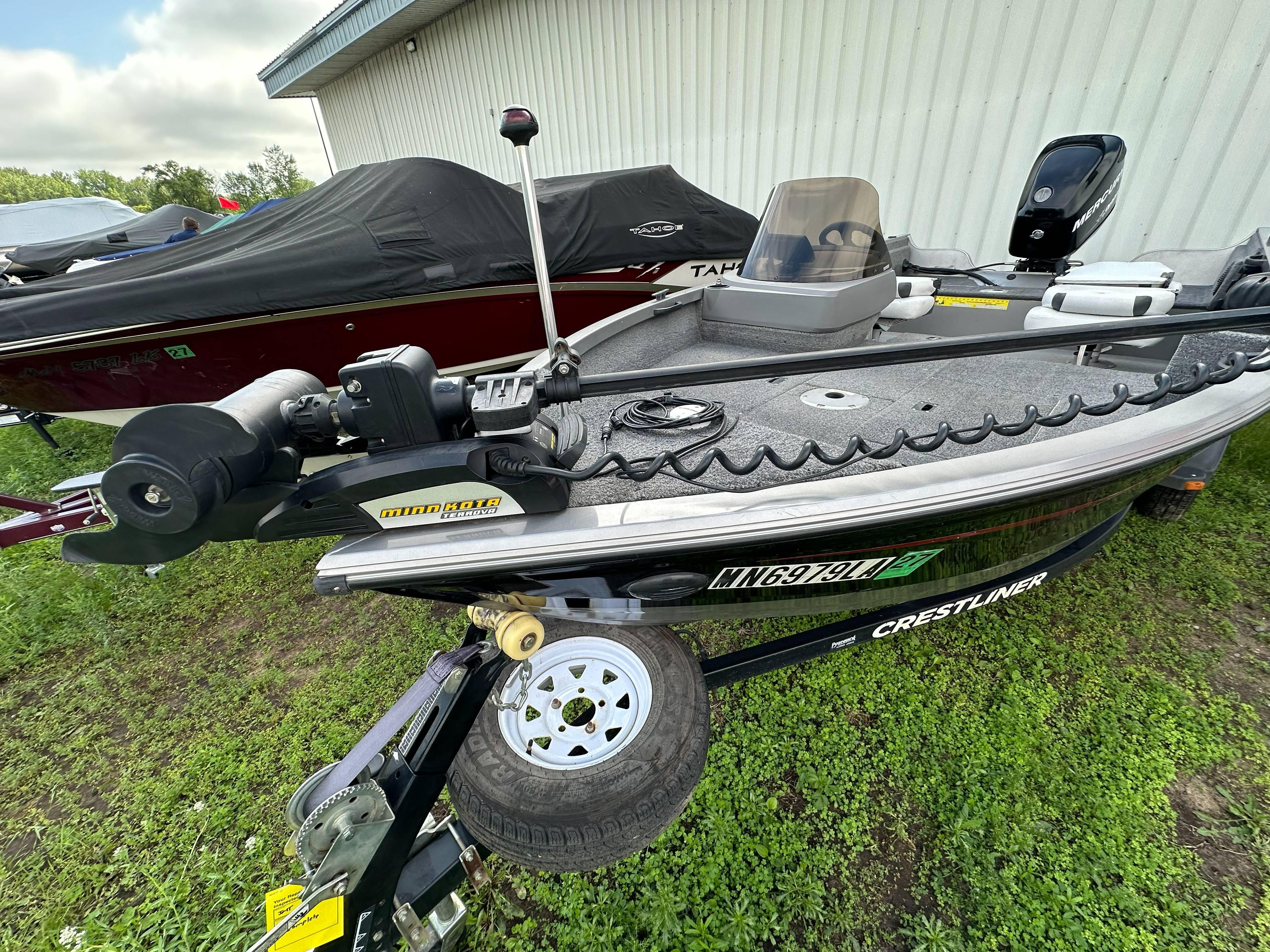 2013 Crestliner Fish Hawk 1650 SC boat with Minn Kota trolling motor, parked on grass.