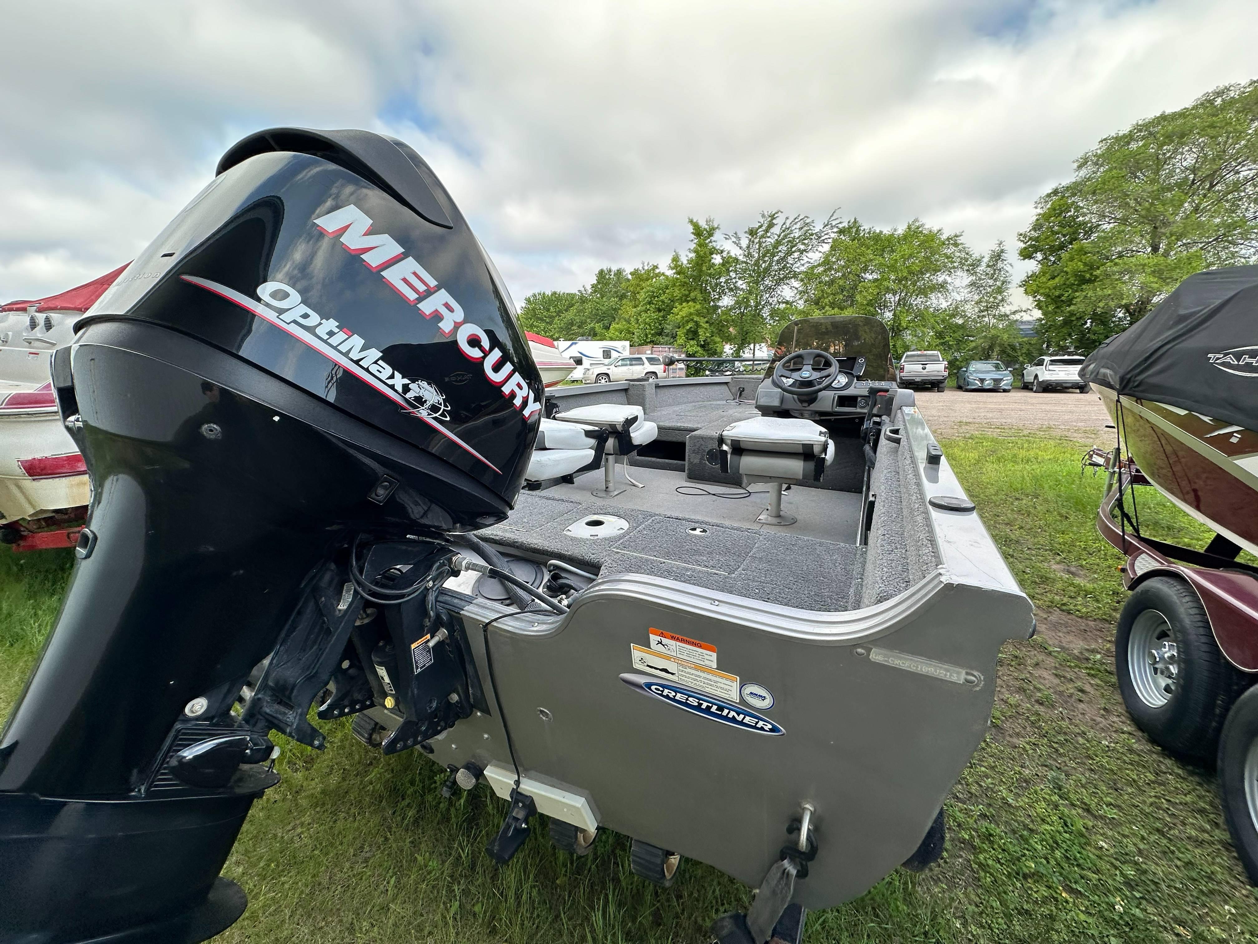 2013 Crestliner Fish Hawk 1650 SC boat with Mercury OptiMax engine, parked outdoors.