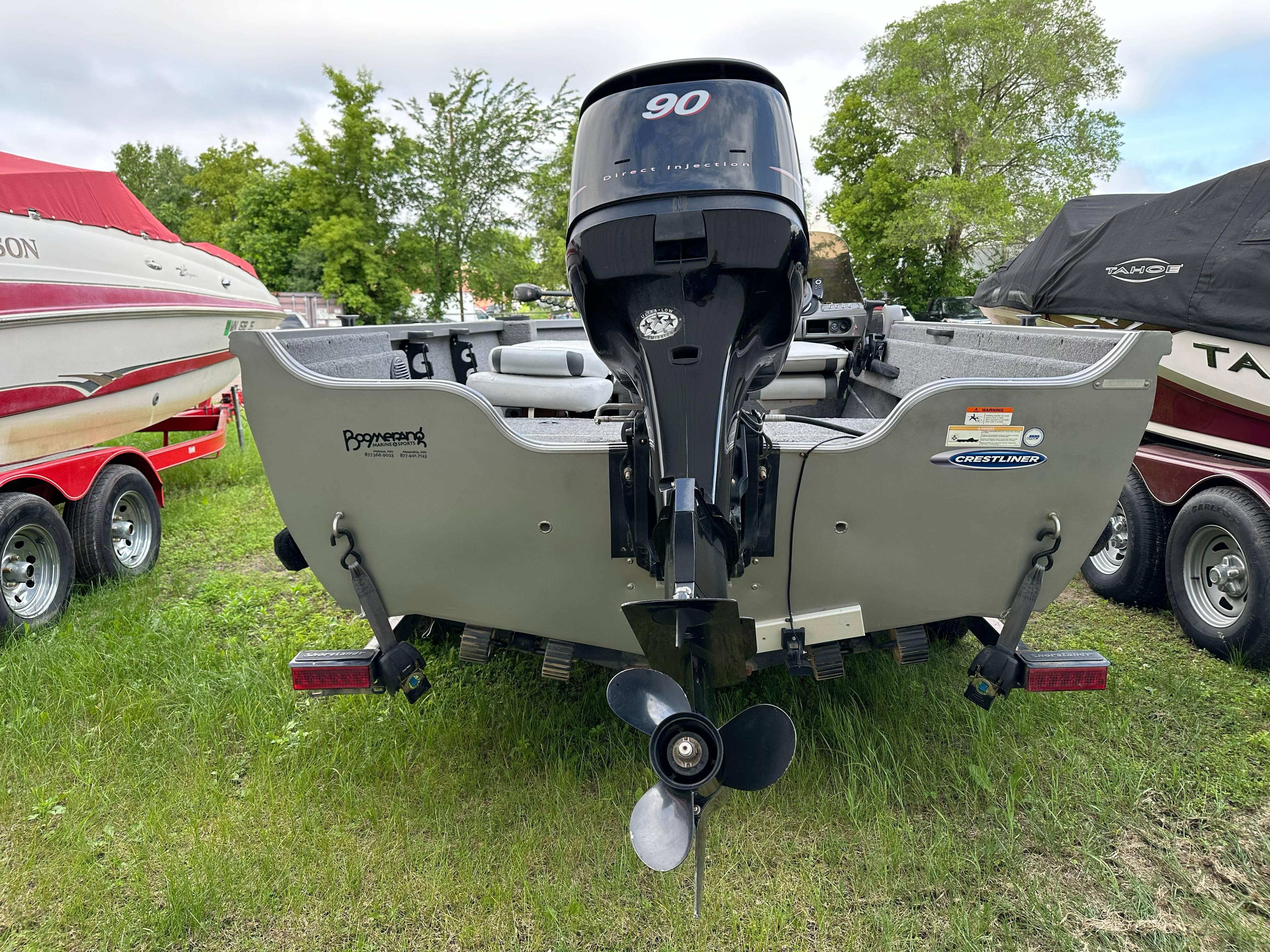2013 Crestliner Fish Hawk 1650 SC boat with outboard motor, parked on grass.