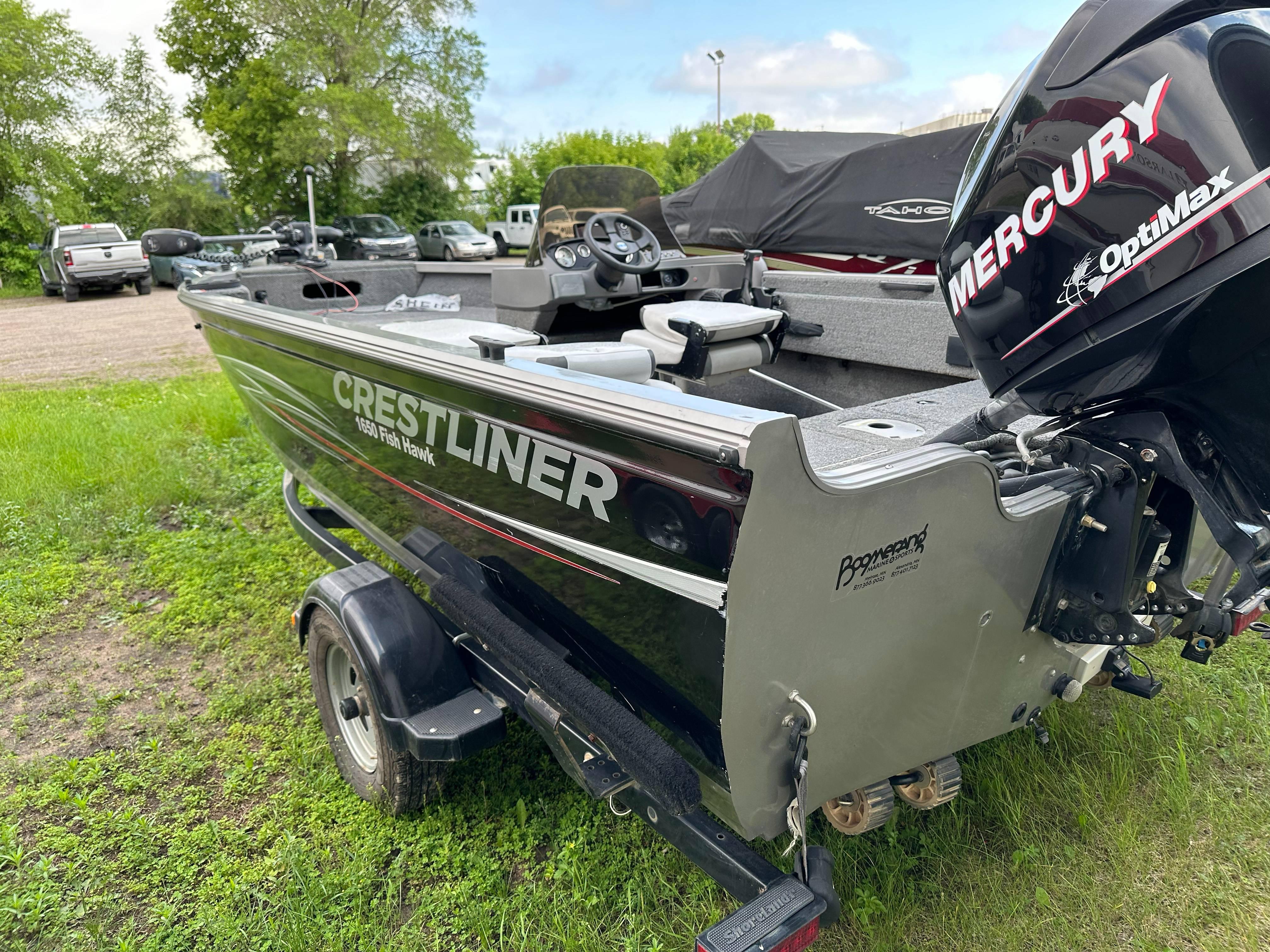 2013 Crestliner Fish Hawk 1650 SC boat with Mercury OptiMax engine on grassy area.