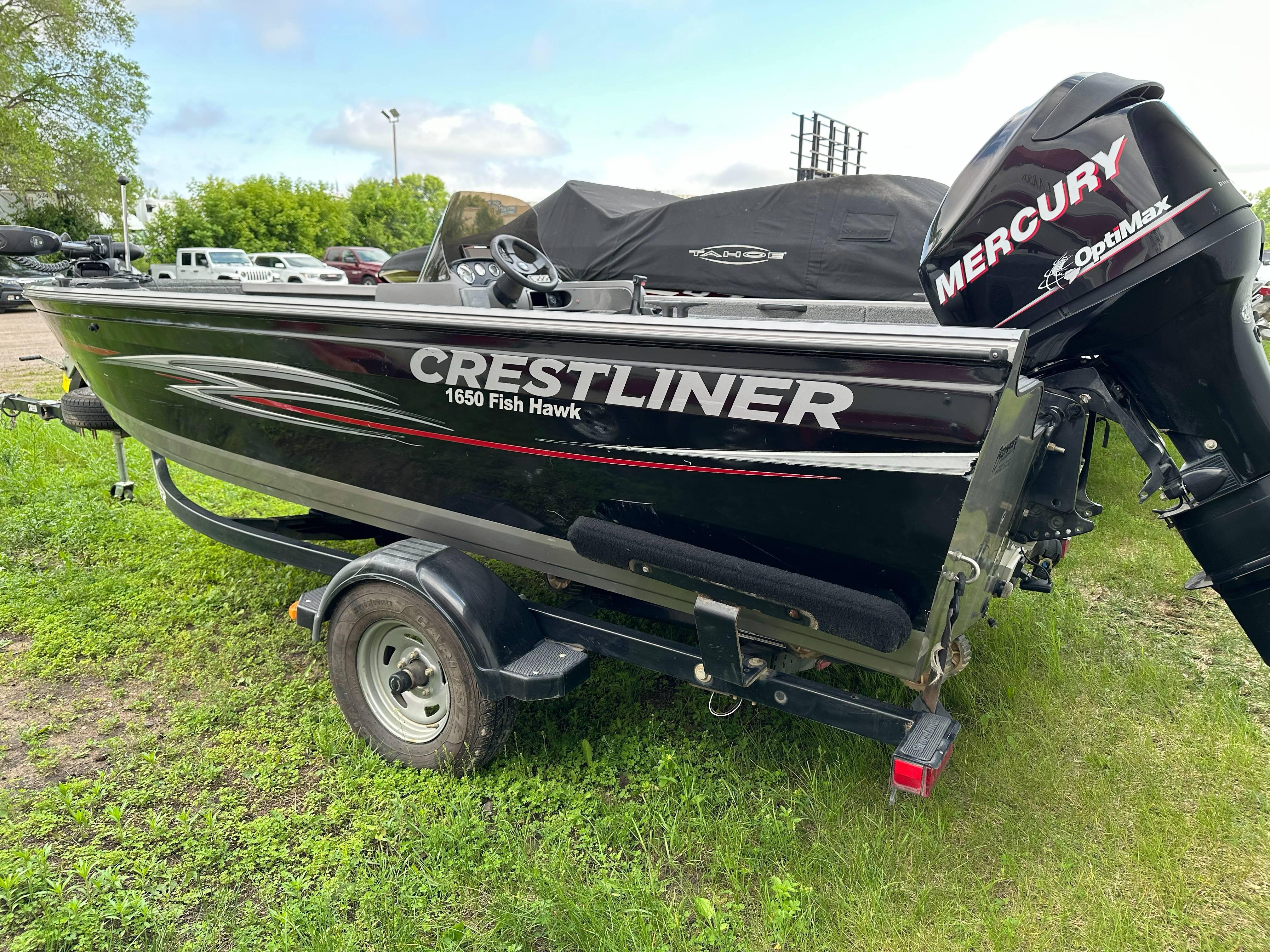 2013 Crestliner Fish Hawk 1650 SC boat with Mercury engine on grassy area.