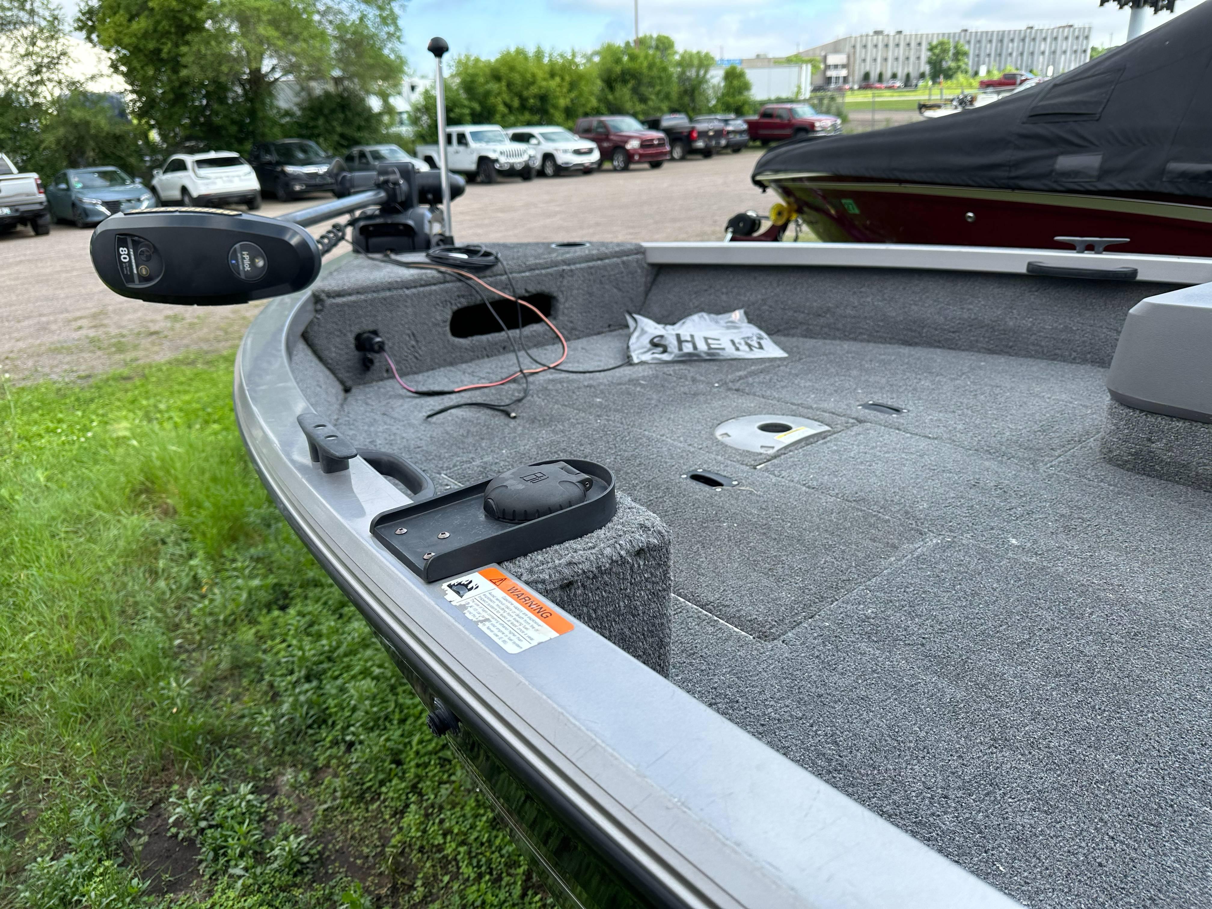 2013 Crestliner Fish Hawk 1650 SC boat interior with trolling motor in parking lot.