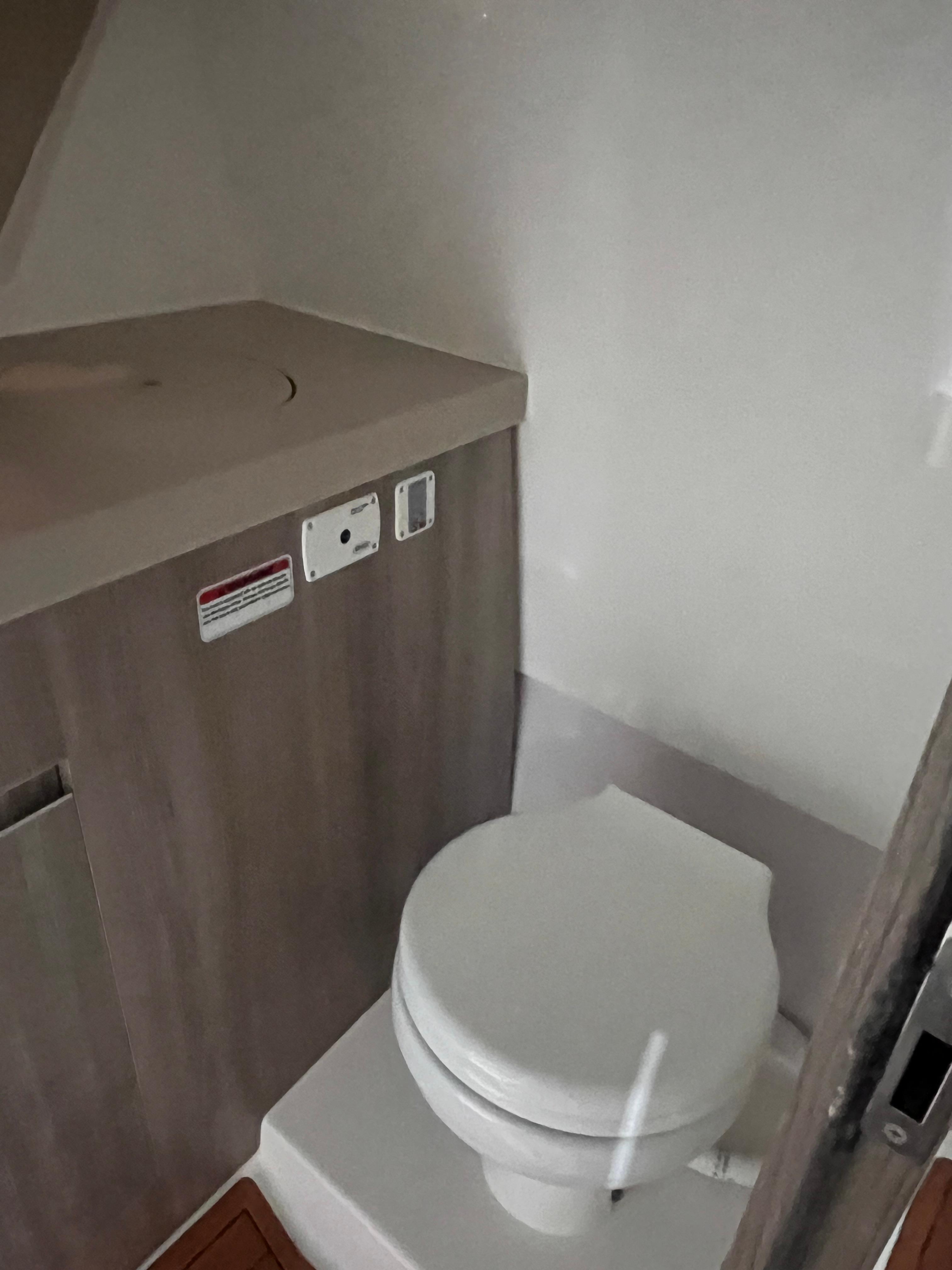 Ventura-DayCruiser 2025 -FL-US-2025 Ventura DayCruiser bathroom interior with compact toilet and wooden cabinetry.-9681900 | Thumbnail
