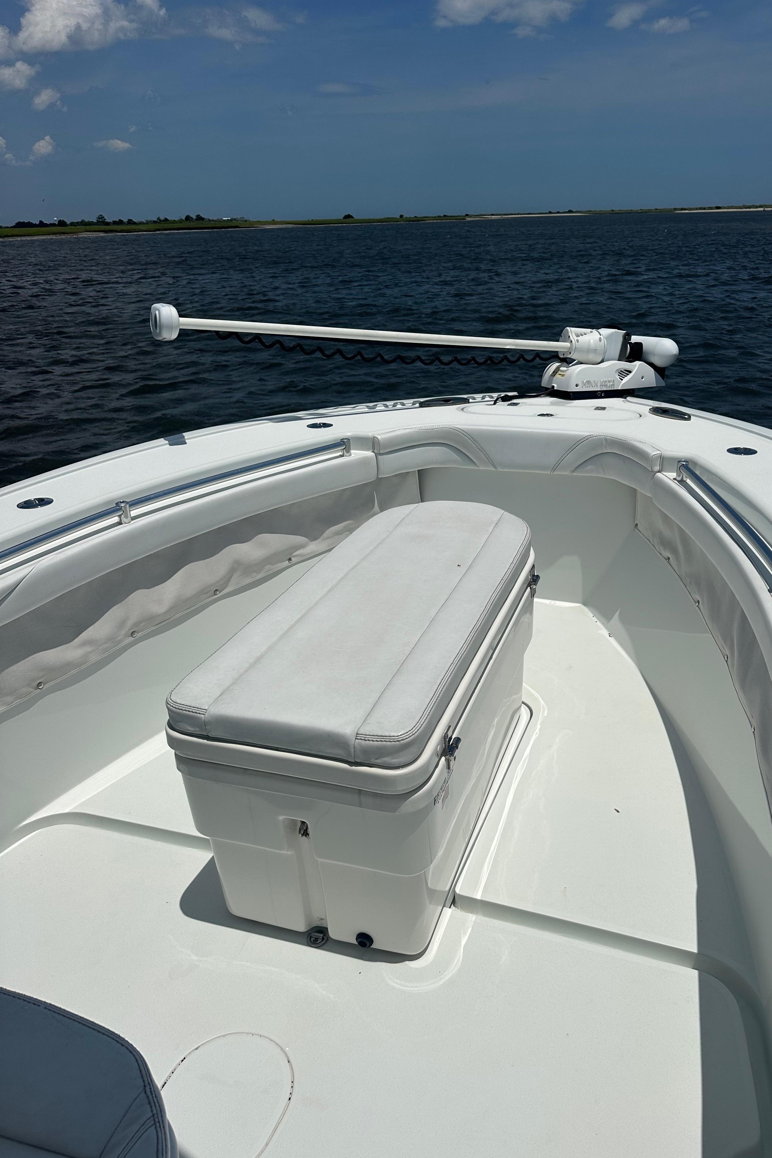 2020 Yellowfin 26 Hybrid boat on calm water, featuring a spacious deck and seating.