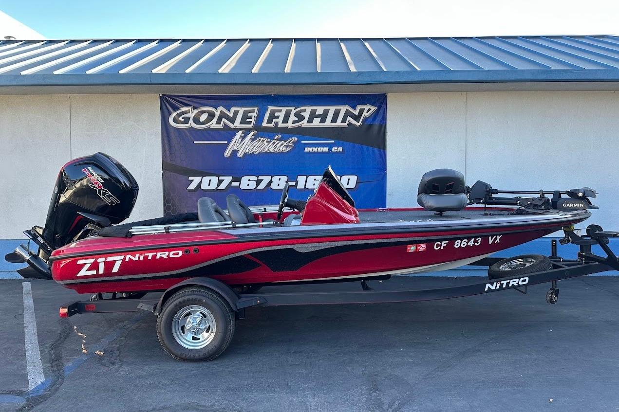2024 Nitro Z17 boat in red, parked on a trailer outside a marine shop.