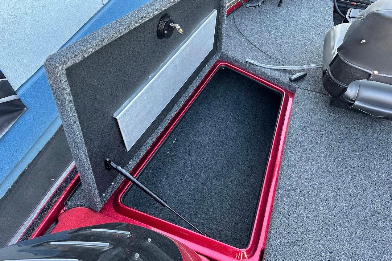Open storage compartment in 2024 Nitro Z17 boat, featuring carpeted interior and hydraulic lift.