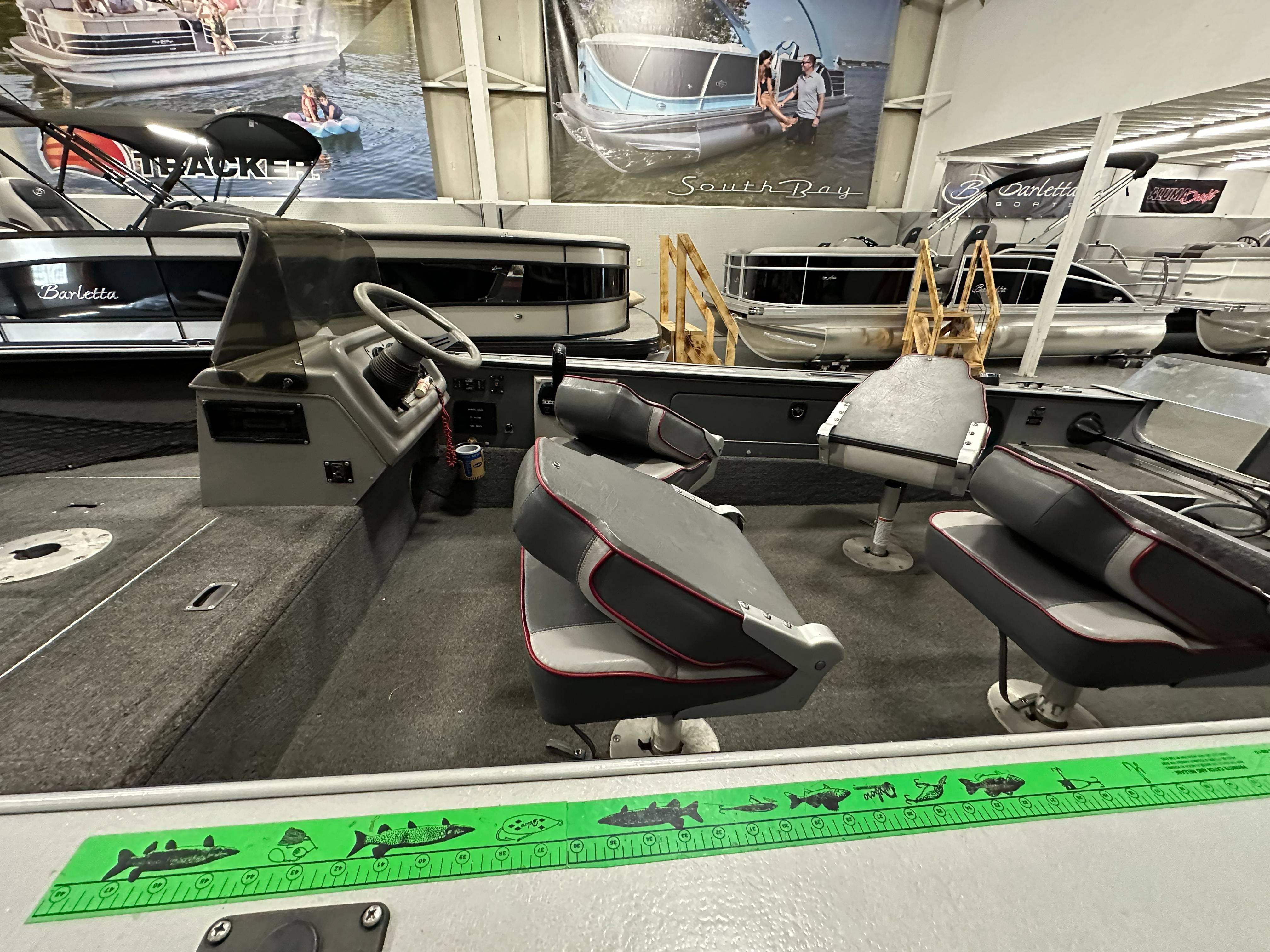 Interior of a 1995 Lund 1650 DLX boat with seating and steering wheel.