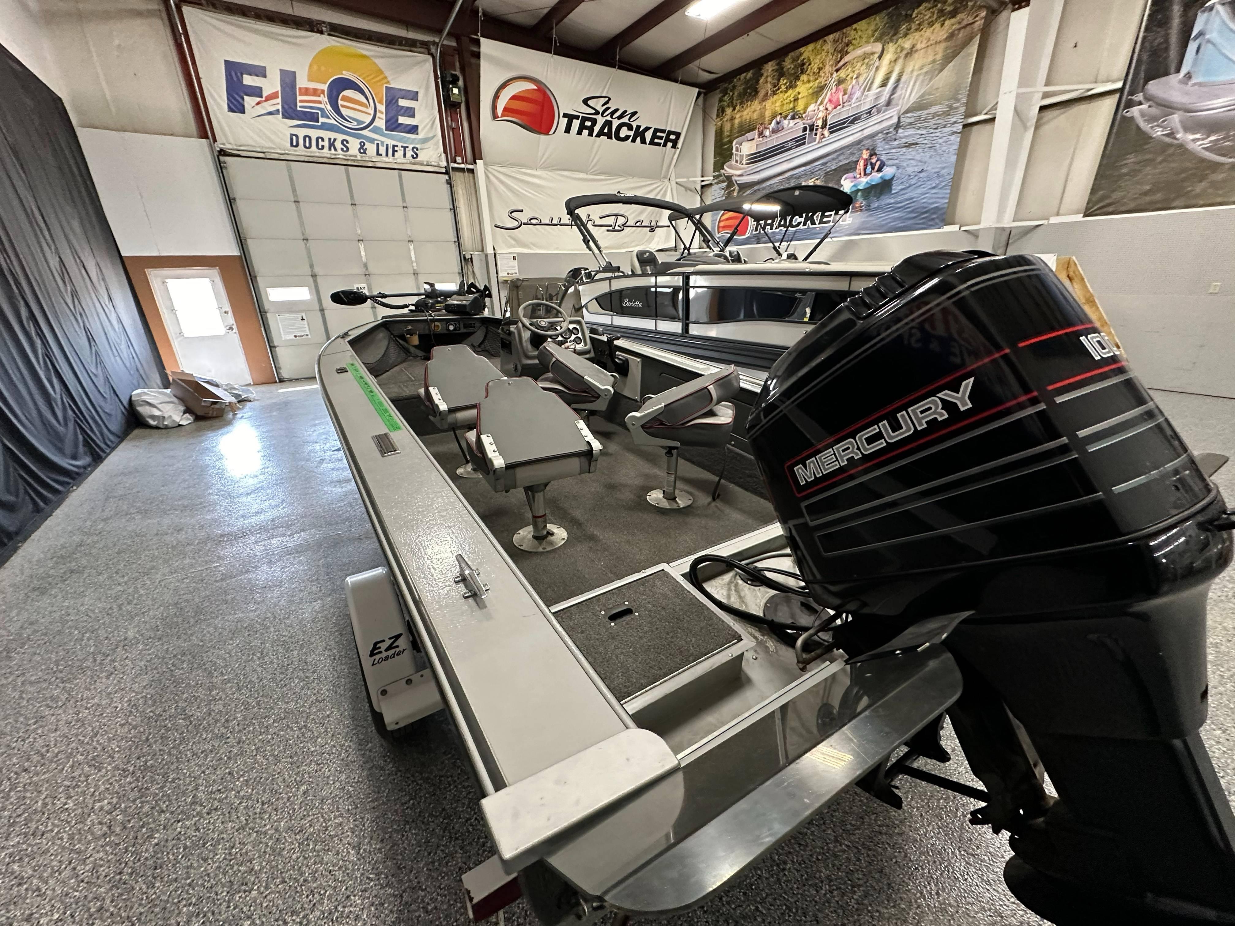 1995 Lund 1650 DLX boat with Mercury engine in showroom.
