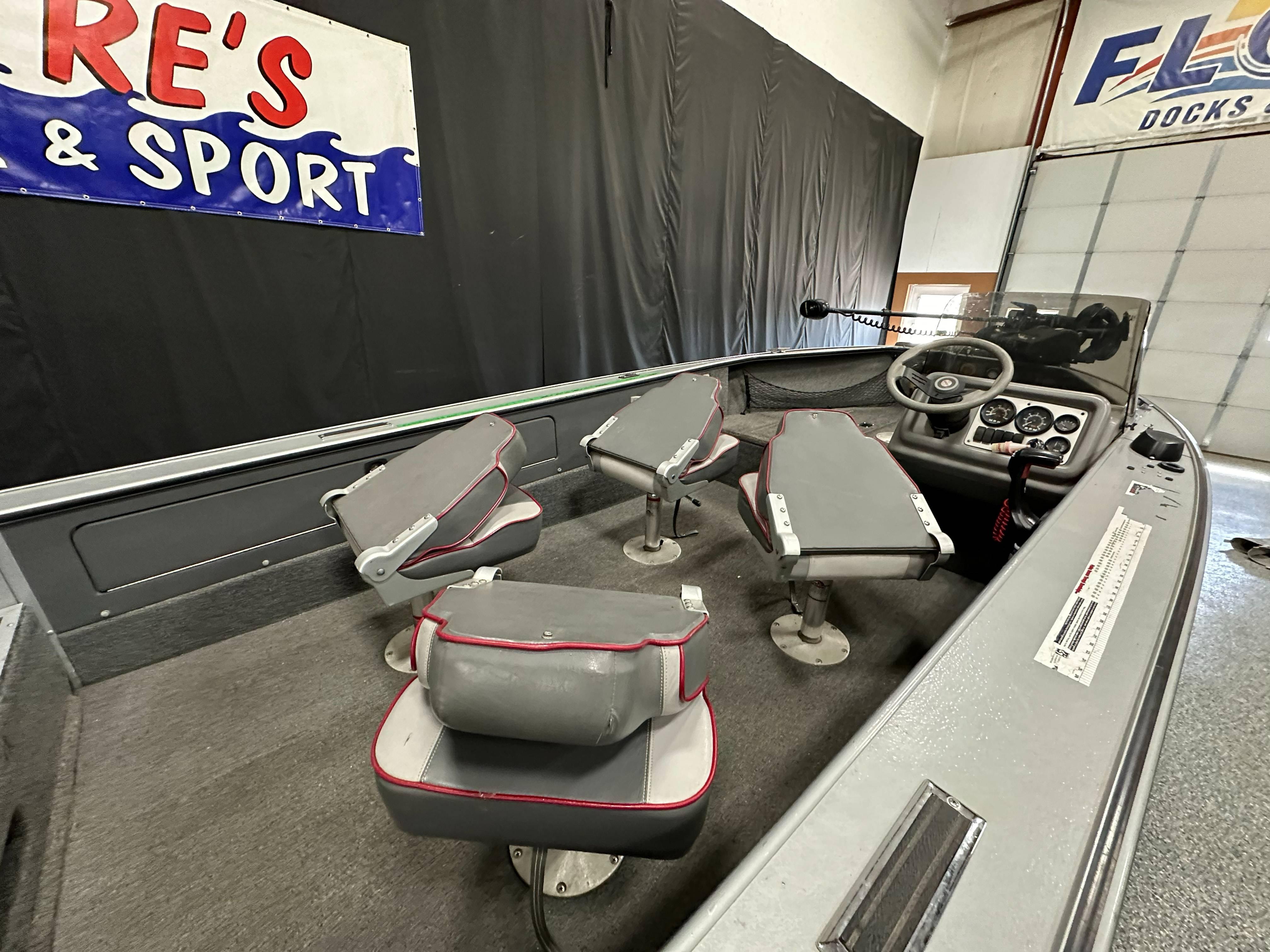 1995 Lund 1650 DLX boat interior with gray seats and steering console.