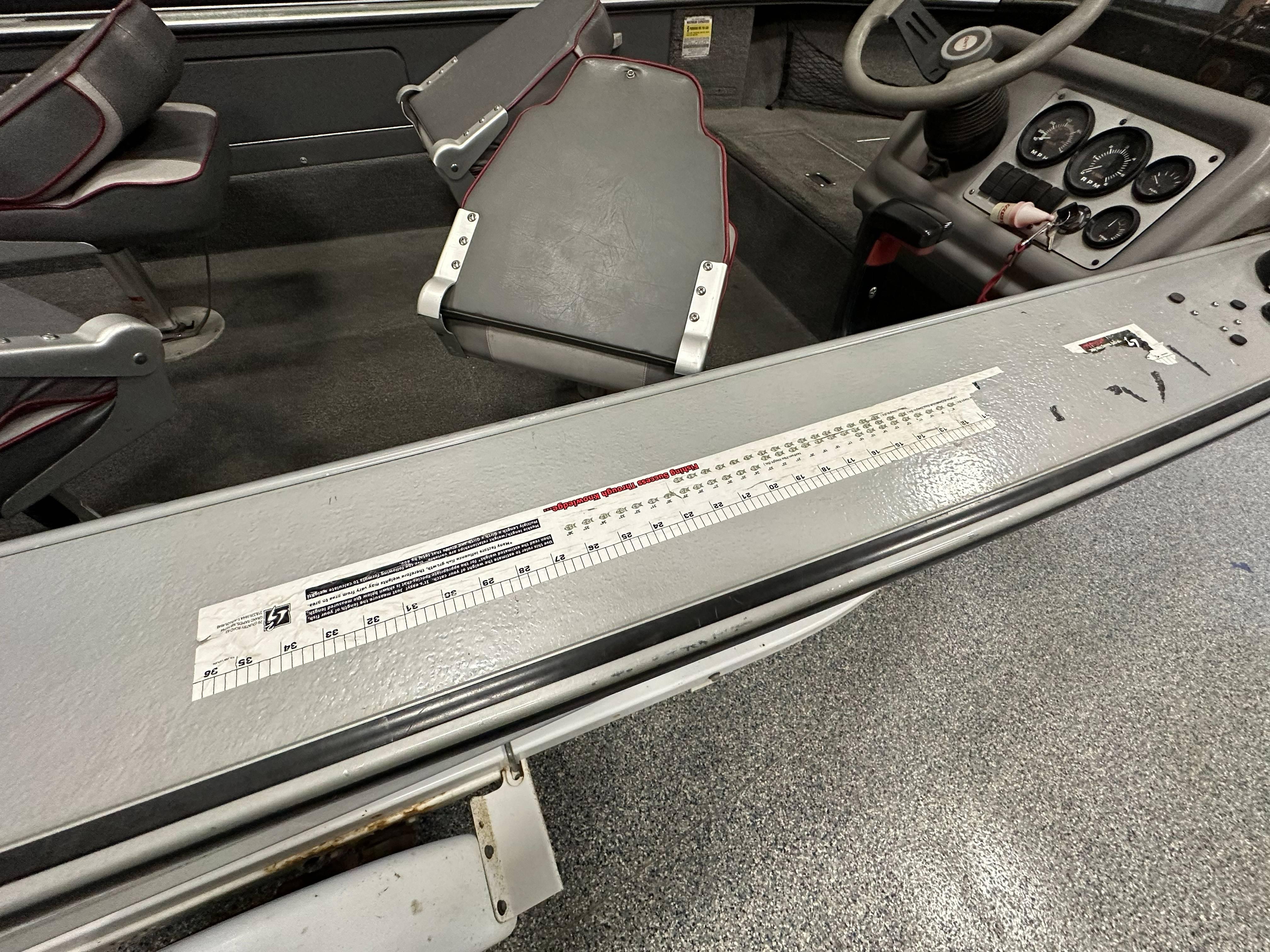 1995 Lund 1650 DLX boat interior with steering wheel and measurement sticker.